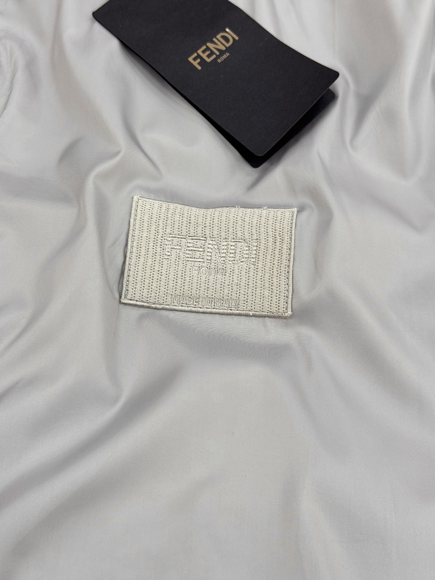 Fendi芬迪春款外套，男女同款！属于时尚服饰范畴。外套采用灰色材质，表面光滑有光泽，内衬带有Fendi