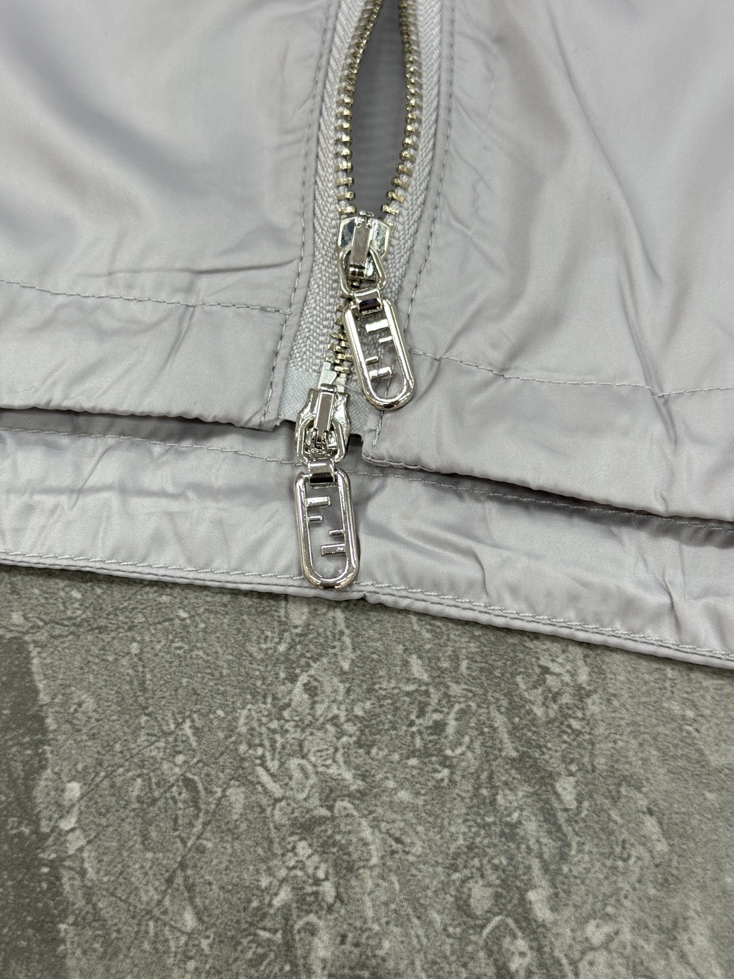 Fendi芬迪春款外套，男女同款！属于时尚服饰范畴。外套采用灰色材质，表面光滑有光泽，内衬带有Fendi