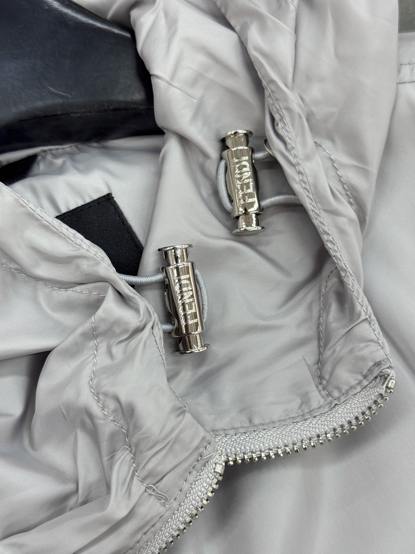 Fendi芬迪春款外套，男女同款！属于时尚服饰范畴。外套采用灰色材质，表面光滑有光泽，内衬带有Fendi