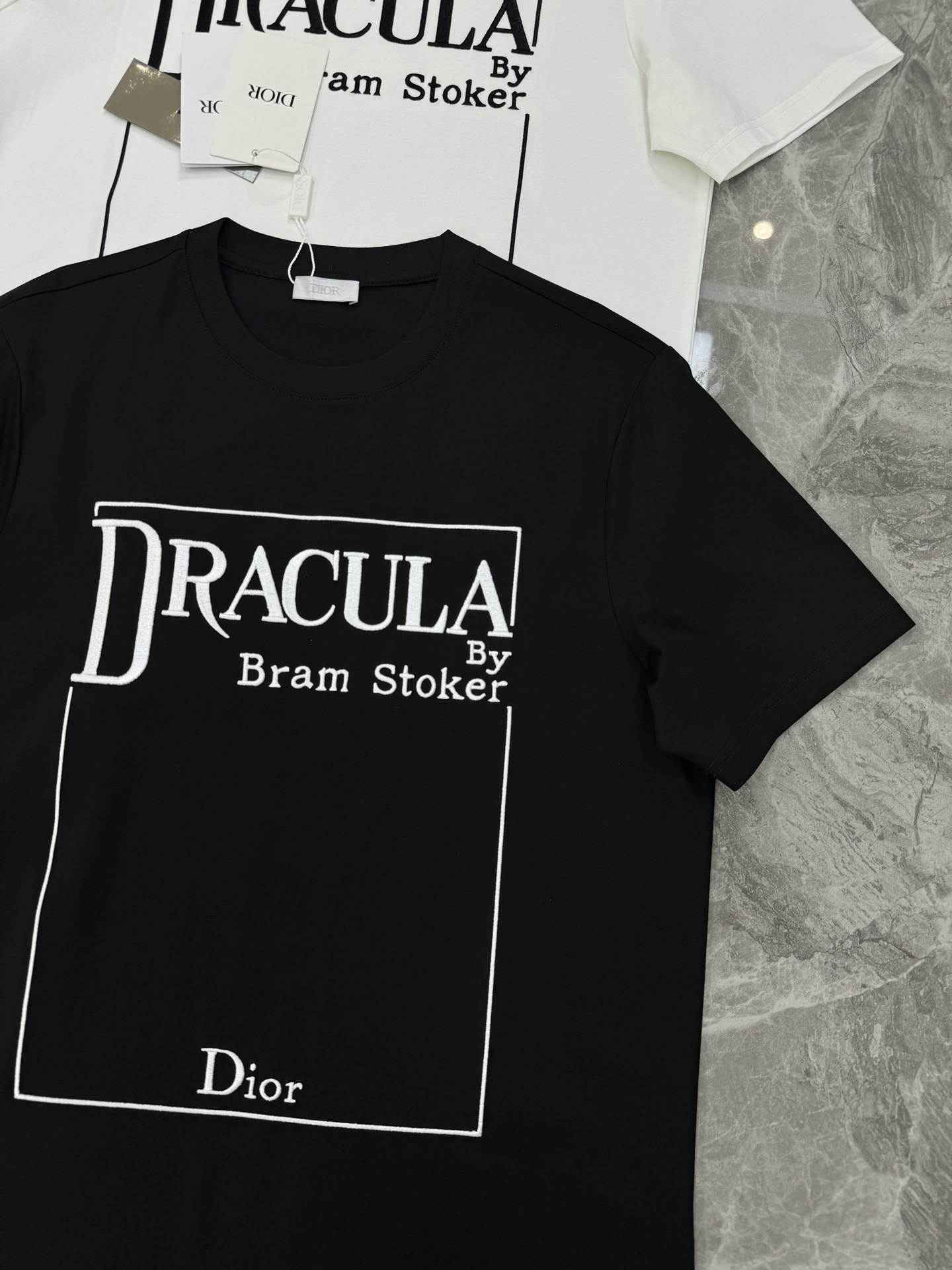 Dior推出的Dracula主题T恤，灵感源自斯托克小说《德古拉》。黑色款搭配白色字体，整体图形刺绣工艺