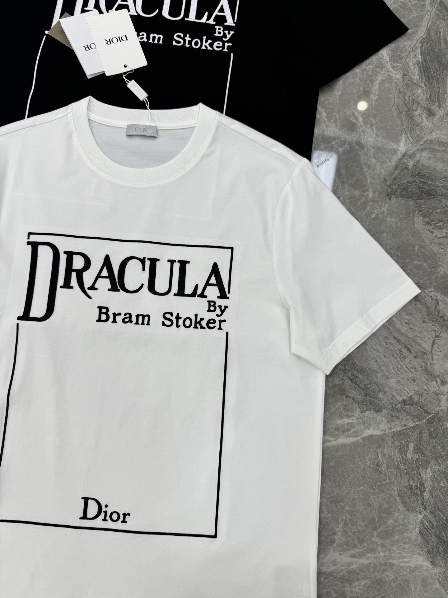 Dior推出的Dracula主题T恤，灵感源自斯托克小说《德古拉》。黑色款搭配白色字体，整体图形刺绣工艺