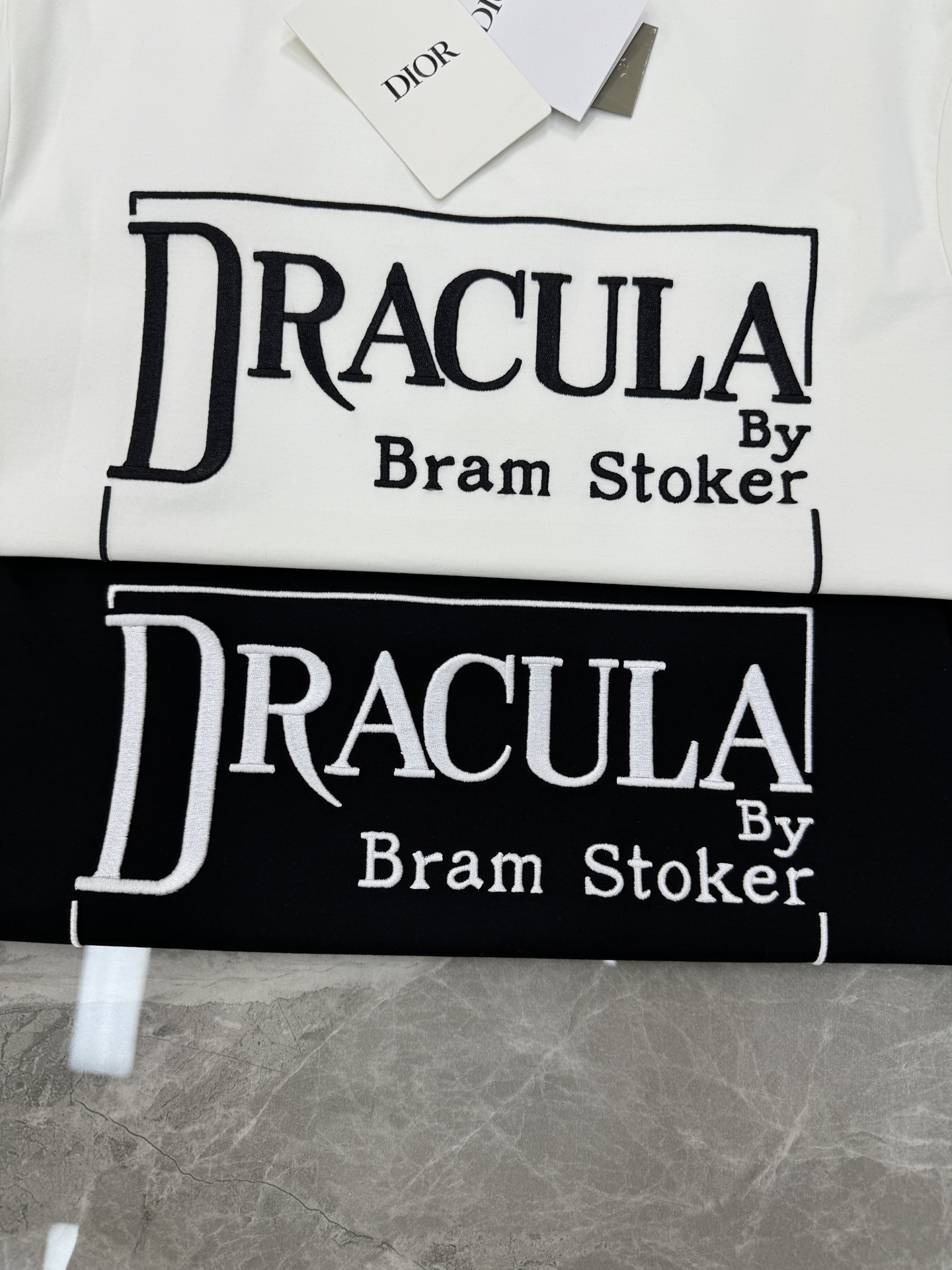 Dior推出的Dracula主题T恤，灵感源自斯托克小说《德古拉》。黑色款搭配白色字体，整体图形刺绣工艺