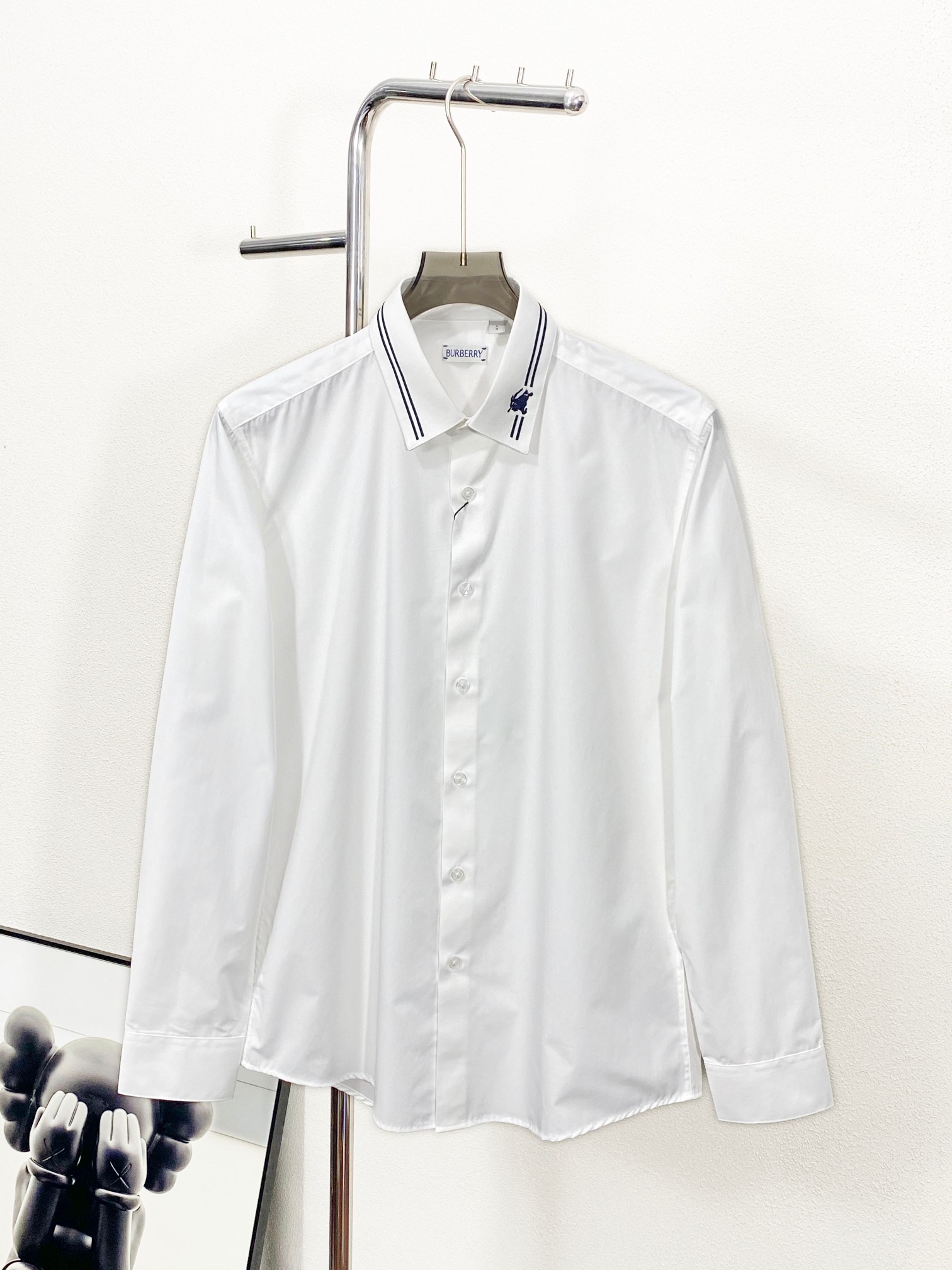 NO:123247,(New Product) BU new white cotton poplin lapel shirt, the same fashion style for men and women, the latest collar blue line embroidered war horse pattern business casual versatile long-sleeved shirt!  There are original Butterfly Green designers, exquisite designs, and BUR is mainly decorated with blue embellishments. This trading company has a wide range of channels and is available on the official website at the same time!  Another solid-color shirt that can be worn all seasons. This shirt has a strong lazy and casual style, without the sense of restraint and seriousness brought by a formal shirt. The ultimate silhouette shirt is an indispensable part of our wardrobe!  This shirt is made of imported white high-quality cotton poplin, with clear and beautiful fabric textures, and the comfortable and skin-friendly feel is beyond your imagination!  The classic war horse pattern on the high-density embroidery bag on the chest uses mercerized blue stitch embroidery technology, which expresses the pattern lines and simple futuristic sense through stitch embroidery. Linear decoration is performed through the same thickness and uniform stitches, adding a three-dimensional and hand-made sense to flat clothing items, which balances fragility and strength!  Customized mother-of-pearl buttons are provided with exquisite brand logos, and the quality is very perfect and detailed!  The shirt-style classic standard neckline and neutral style design does not limit gender and age. Apart from the simple stitch embroidery pattern, there is no extra complex design, the colors are also refreshing and clean, and the details reveal the unscathing professionalism and calm calmness!  Recommended for the same style as men and women!  Size M-XXXL, burberry,shirts,alexander wang19860909(新品)BU新款白色棉府绸翻领衬衣,男女同款时尚最新衣领蓝线刺绣战马图案商务休闲百搭长袖衬衫！有原蝴蝶绿设计师,精致设计,BUR主打蓝色点缀,此款贸易公司渠道稀出,同步官网发售！又是一款四季可穿的纯色系衬衫,这款衬衫它带着一股浓浓的慵懒休闲风,没有那种正装衬衫带来的束缚感和严肃感,极致的廓形衬衫是我们衣柜里必不可少的！ 这款衬衫采用客供进口白色优质棉府绸制成,面料织纹清晰美观,着身的舒适亲肤感超乎你的想象！胸前高密度刺绣袋处经典战马图案采用丝光蓝线迹绣花工艺,通过线迹绣花的方式表现出图案线条和简约的未来感,通过粗细相同和均匀的针脚进行线性装饰,为扁平的服装单品增加了立体感,手工感,将脆弱与力量做出了美的平衡！客供定制珍珠贝母纽扣,并刻有精致的品牌Logo,品相非常完美细致！衬衫式经典标准领口和中性风格设计,不限制性别年龄,除简约的线迹刺绣图案外没有多余的繁复设计,颜色也是清爽干净,细节中透露出心无旁怠的专业和不动声色的冷静！男女同款推荐！尺码M-XXXL,,burberry,shirts,alexander wang,Men's clothing