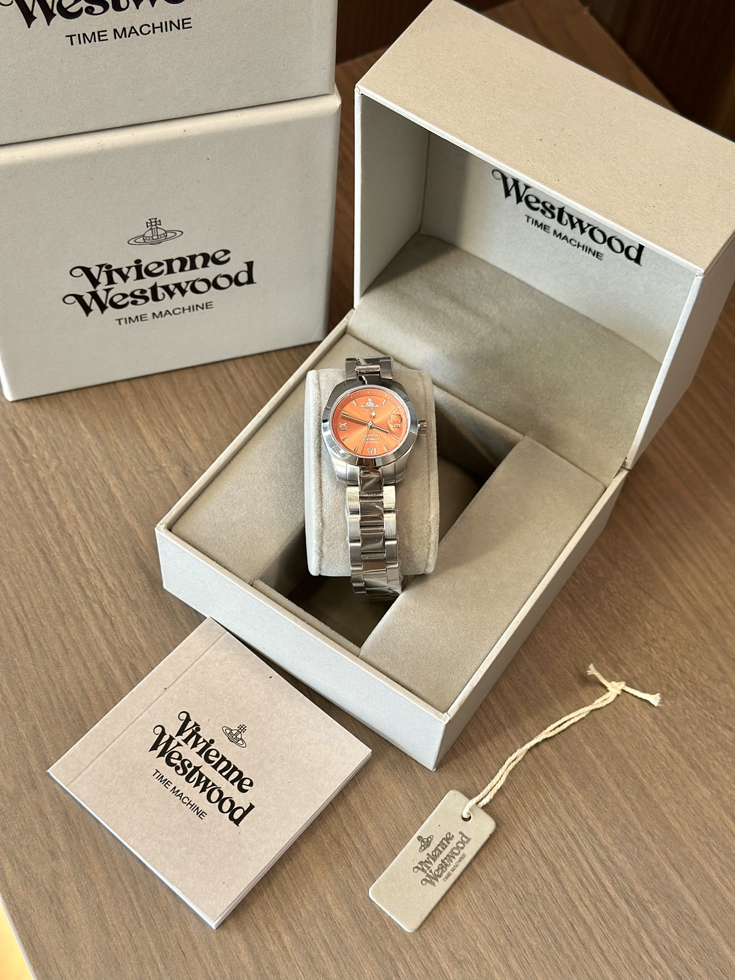Distinguished by a bold orange dial paired with a silver-tone bracelet - Jewelry