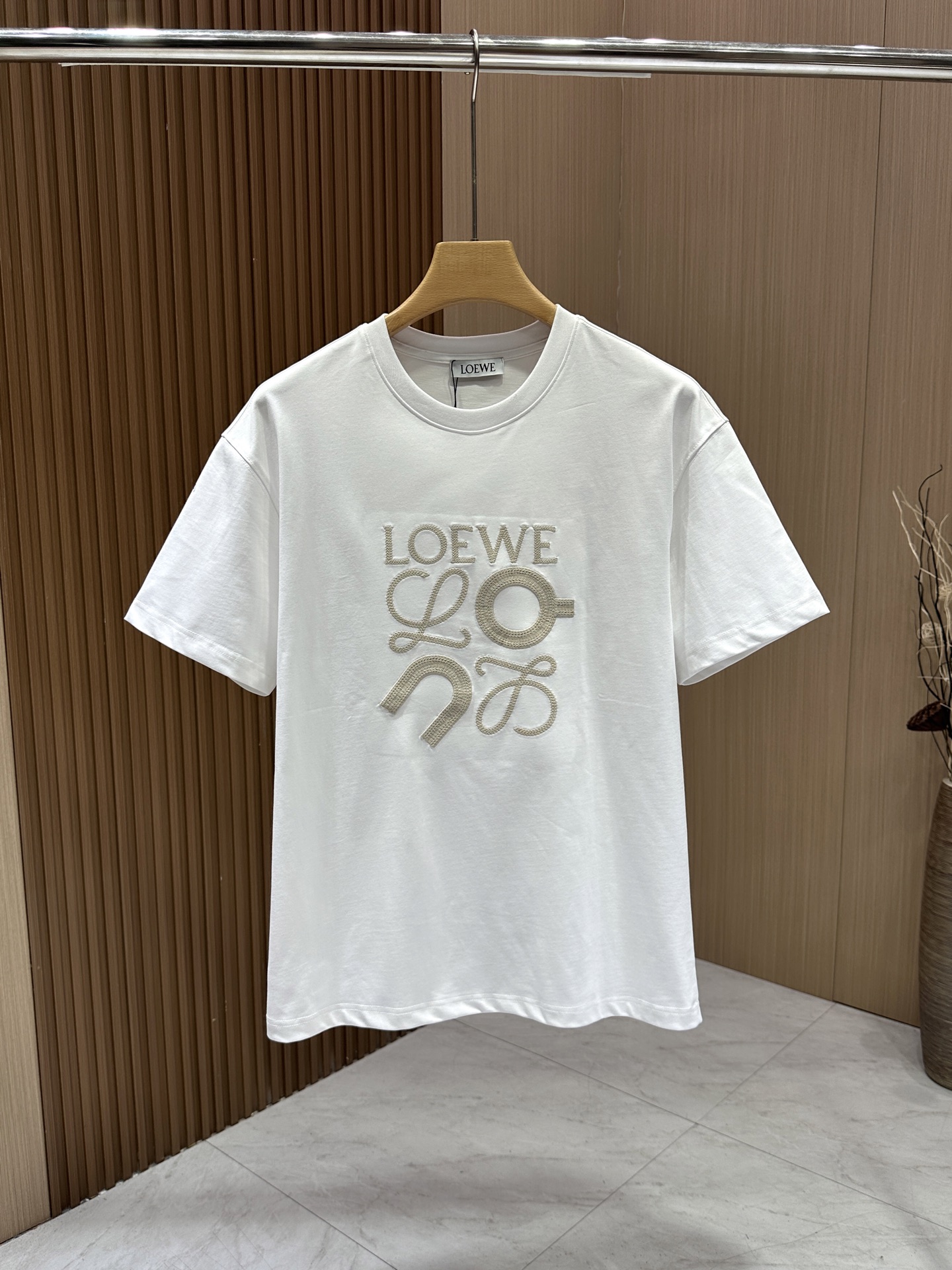 PZW。【Loewe】罗意威 春夏新款限定错位刺绣图案短袖，圆领宽松休闲惬意，适合日常生活的各种场合，简约纯色的大身，胸前田岛机立体错位刺绣元素图案点缀，是罗意威限定的全新设计，珐琅工艺的摆件造型一般，重工艺，刺绣有LOEWE的字母标识，低调却依然有着清晰的辨识度，限定的代表作有着独特的个性，轻松拥有时尚look。全棉精梳纱，正品级，品质感十足，春季侘寂色系的Tee不得不夸Loewe可太会了，极限推荐!/非常耐看简单又松弛，这款Tee就是硬通货，配任何颜色下装都不会出错!喜欢的快来get同款吧！\n码数：S- XXL\n颜色：黑色-白色