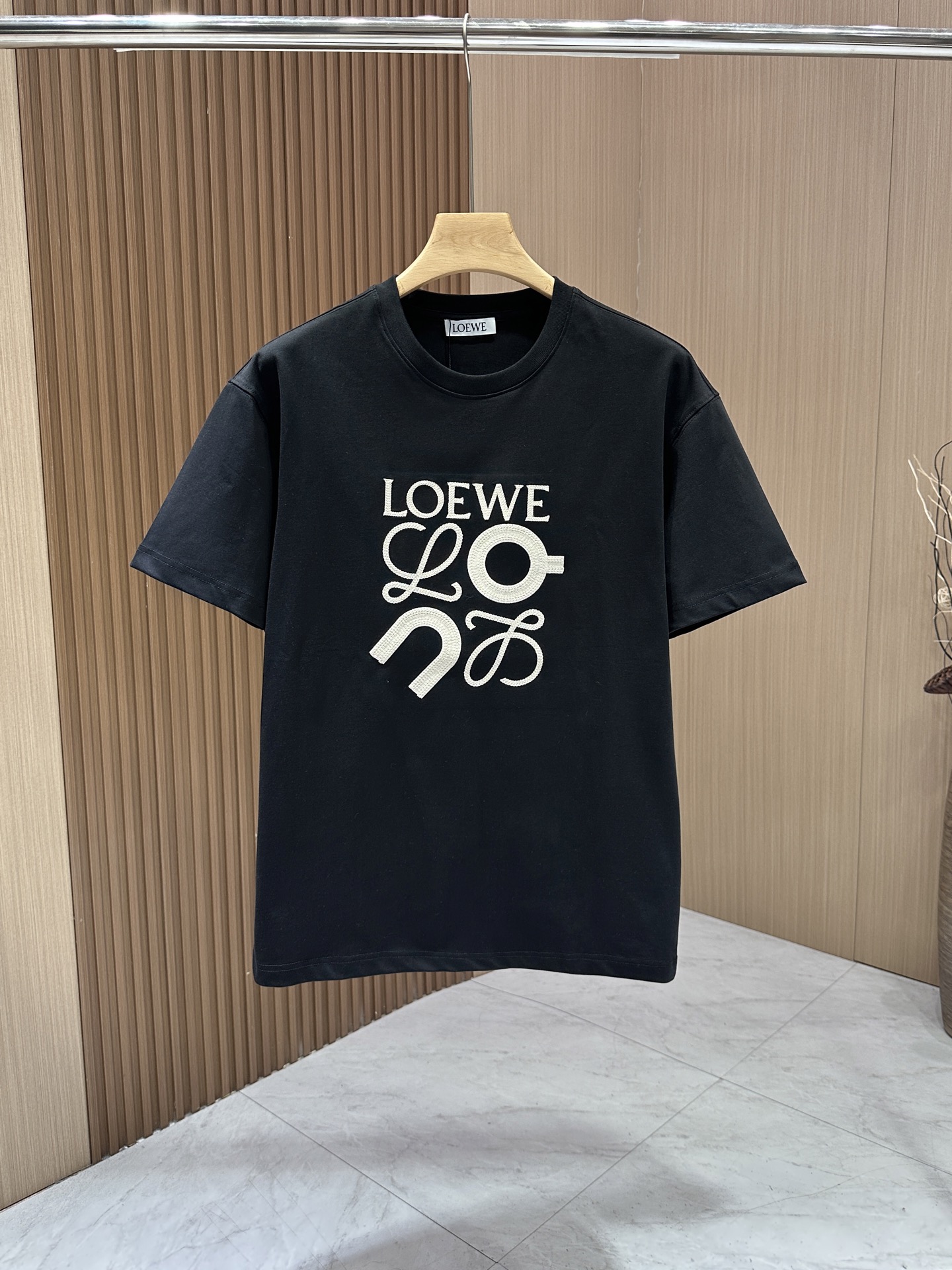 PZE  【Loewe】罗意威 春夏新款限定错位刺绣图案短袖，圆领宽松休闲惬意，适合日常生活的各种场合，简约纯色的大身，胸前田岛机立体错位刺绣元素图案点缀，是罗意威限定的全新设计，珐琅工艺的摆件造型一般，重工艺，刺绣有LOEWE的字母标识，低调却依然有着清晰的辨识度，限定的代表作有着独特的个性，轻松拥有时尚look。全棉精梳纱，正品级，品质感十足，春季侘寂色系的Tee不得不夸Loewe可太会了，极限推荐!/非常耐看简单又松弛，这款Tee就是硬通货，配任何颜色下装都不会出错!喜欢的快来get同款吧！\n码数：S- XXL\n颜色：黑色-白色