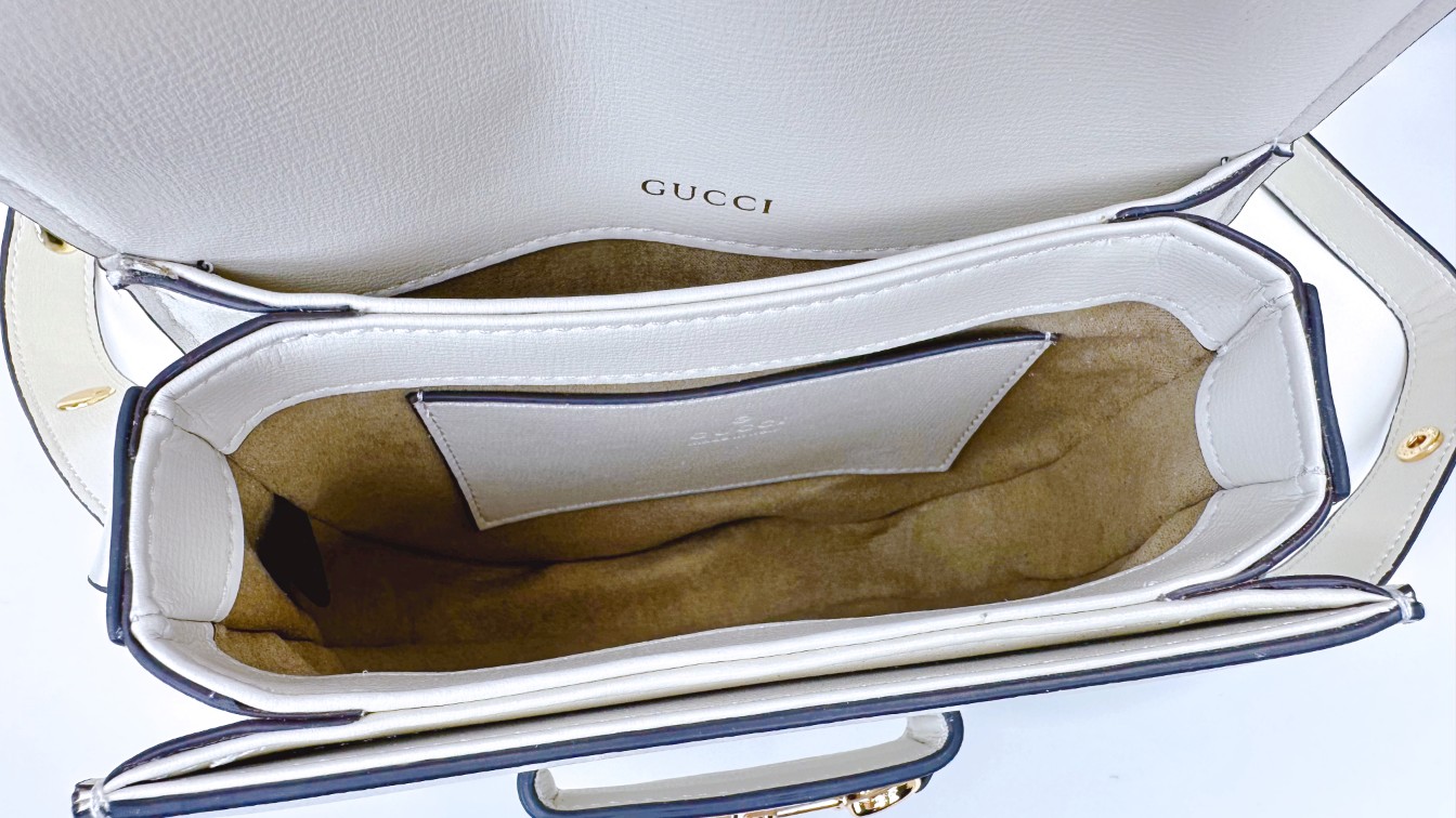 迷你斜挎马鞍包古驰《Aria-时尚咏叹调》系列运用现代手法焕新演绎经典元素。竹节是古驰的经典元素之一，自