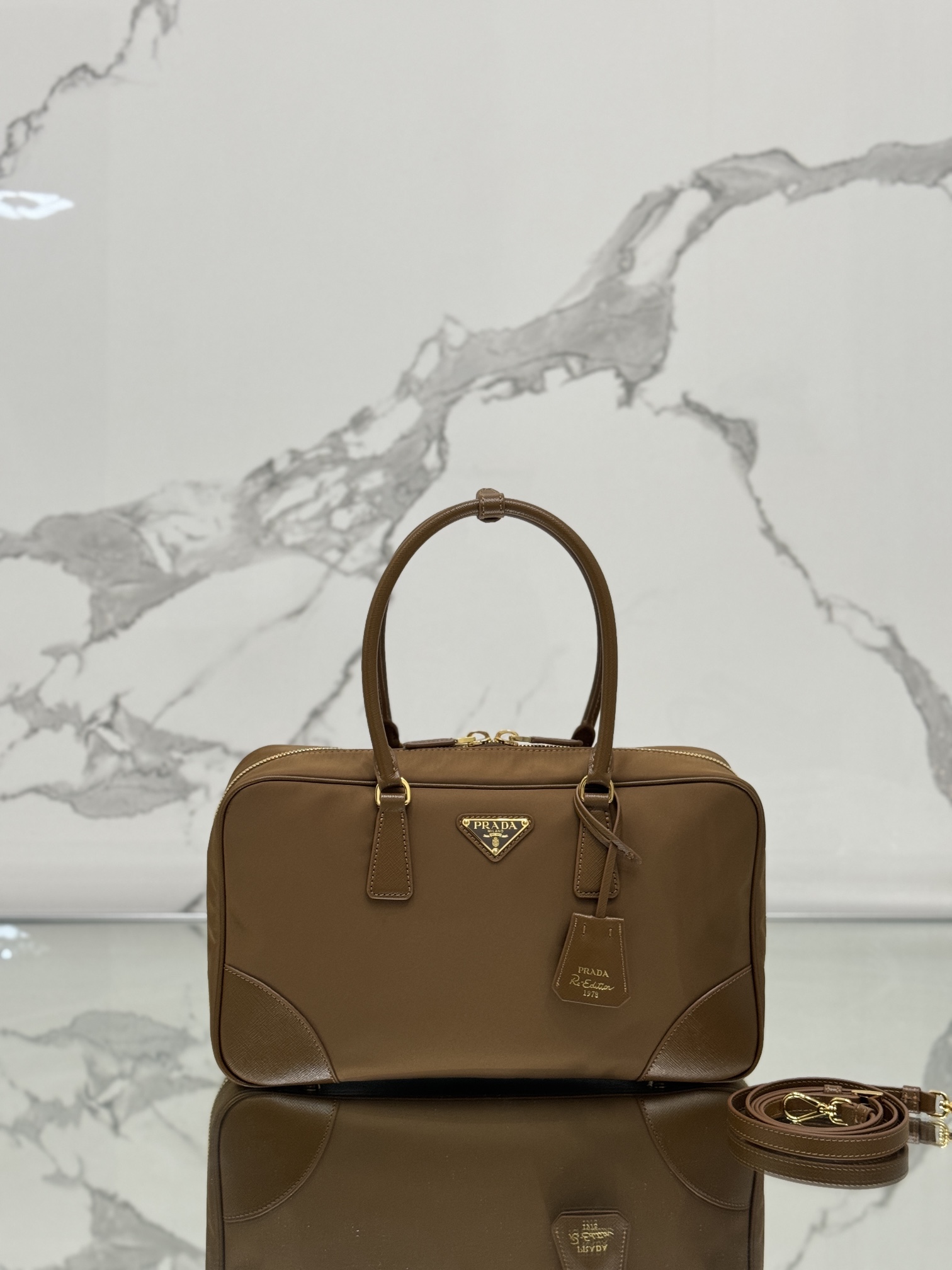 NO:390562,Double-handle handbag (large size) This model is made of recycled nylon, incorporates unique style elements and matches the exquisite Saffiano leather details, completely subverting people's perception of luxury traditions. It adds a unique charm between practical design embellishments and exquisite details. Size length 35x height 21.5x bottom 10cm model number 1BB114, Prada [top original list], prada19860909双提手手袋(大号) 这款选用再生尼龙打造,融入特有的风格元素,搭配精致的Saffiano皮革细节,彻底颠覆人们对奢侈品传统的认知.在实用的设计点缀和精致的细节之间增添了独特的韵味. 尺寸长35x高21.5x底10cm 款号1BB114,普拉达【顶级原单】,prada,Bag