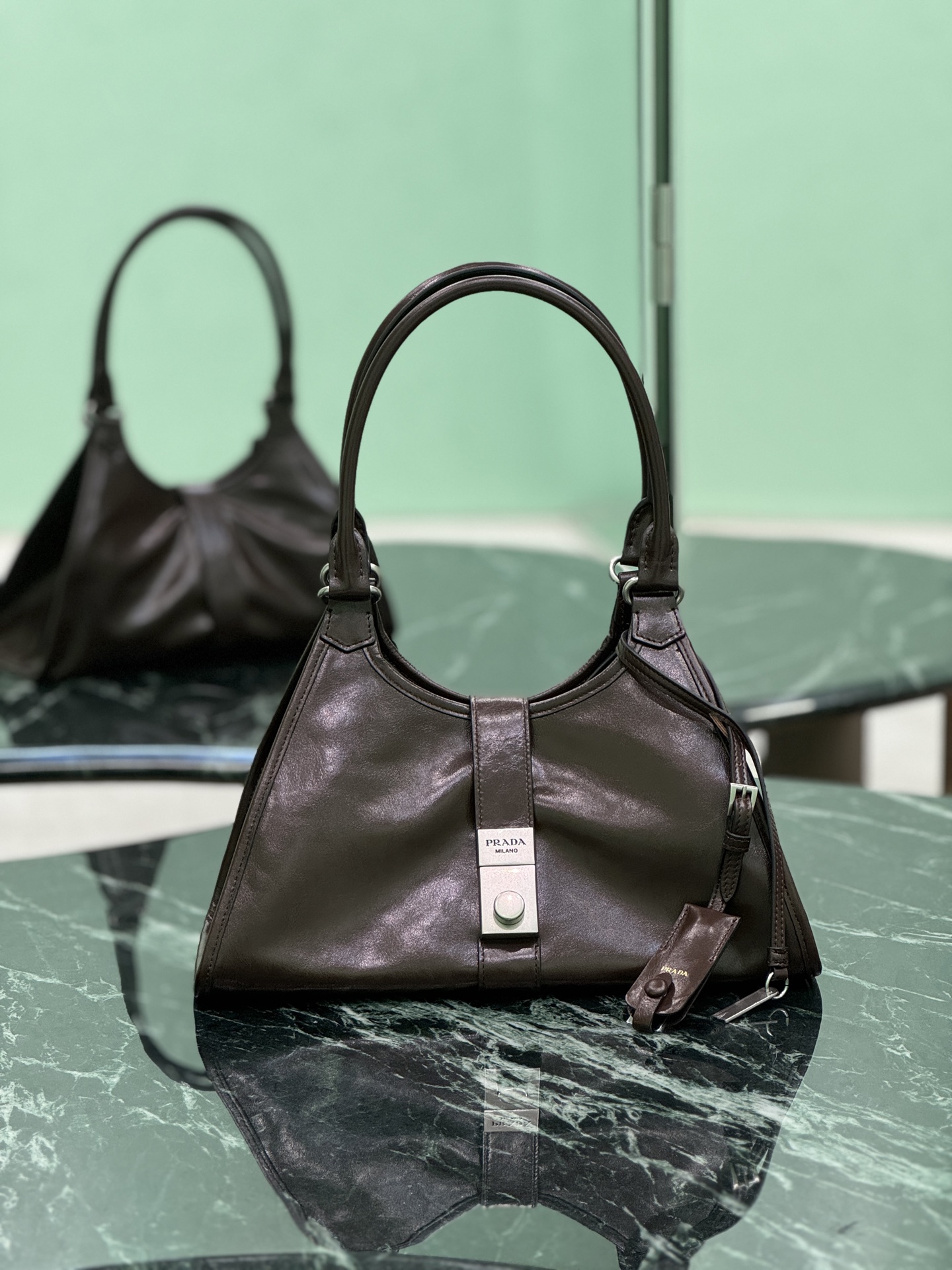 NO:582579,New model for spring and summer (small size). This catwalk model is made of imported waxed leather, top-grade hardware, and the front panel is equipped with a buckle lock opening and closing. It has a large capacity and can be carried by hand or on the shoulder. Dimensions: length 30.5x height 17.5x bottom 9cm. Style number 1BG563, Prada [top original order], prada19860909春夏新款(小号) 这款走秀款采用进口油腊皮,顶级五金,前幅配有插扣锁开合,容量空间大,又可手提又可肩背. 尺寸长30.5x高17.5x底9cm 款号1BG563,普拉达【顶级原单】,prada,Bag