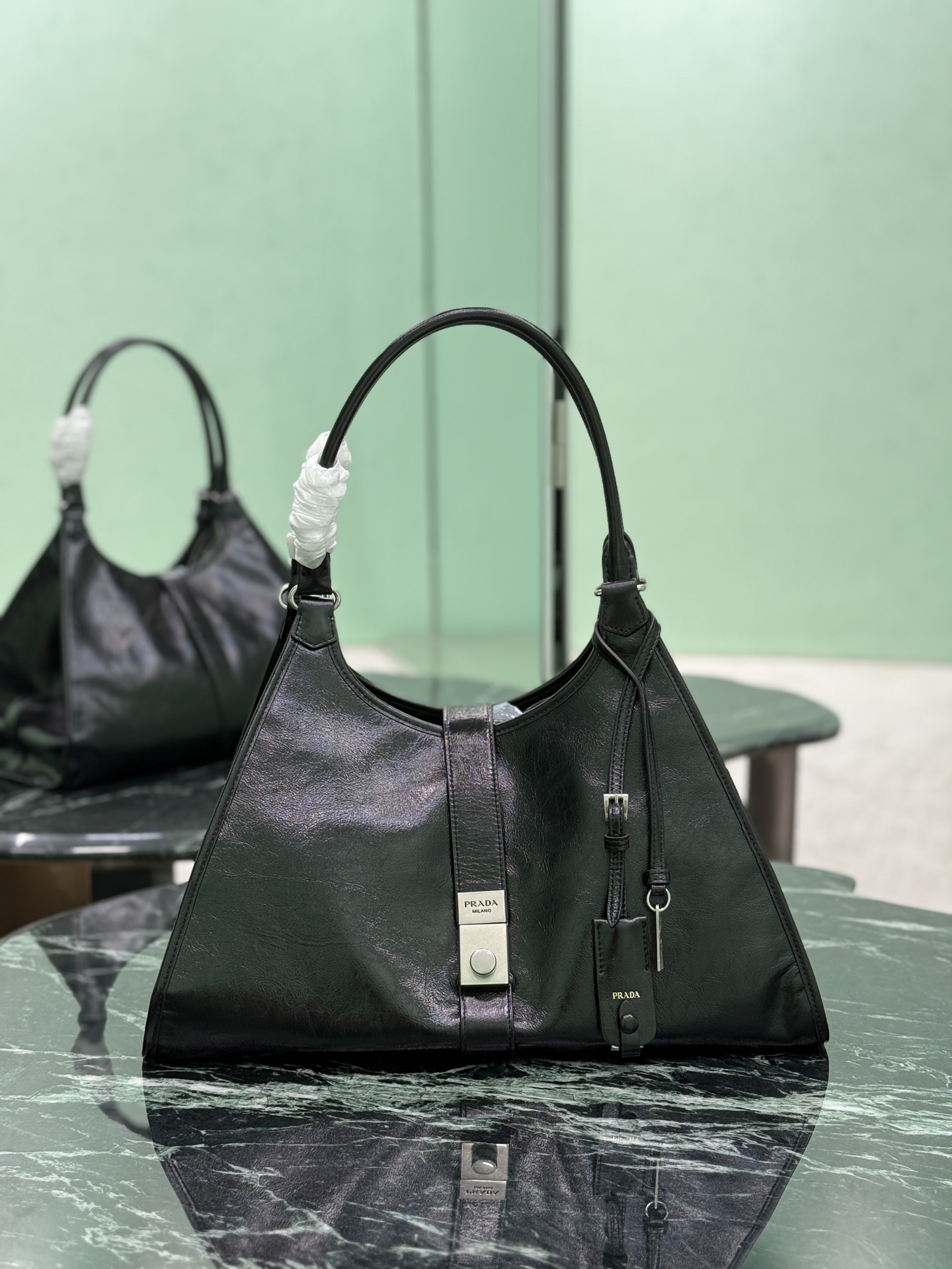 NO:582573,(Large size) The latest spring and summer catwalk model, geometric lines and exquisite ingenious details are the highlights of this soft-bodied handbag. The trapezoidal silhouette is equipped with a slender handle, which can also be easily carried as a shoulder bag. The design of the vertical lock buckle is inspired by the archives, and the leather mirror adds a touch of sophistication. The leather handle has a drop length of 25 cm. Dimensions are 42 cm long x 28 cm high x 20 cm bottom.  Style number 1BG570, Prada [top original order], prada, shoulder bags19860909(大号) 春夏最新走秀款,几何线条与精致匠心细节,是这款柔美体量手袋的亮点所在.梯形廓形配以纤长手提柄,亦可作为单肩包轻松肩背.竖向锁扣的设计灵感源自档案库,皮革镜子平添一抹精致之感.皮革手提柄,垂长25厘米. 尺寸长42x高28x底20cm 款号1BG570,普拉达【顶级原单】,prada,shoulder bags,Bag