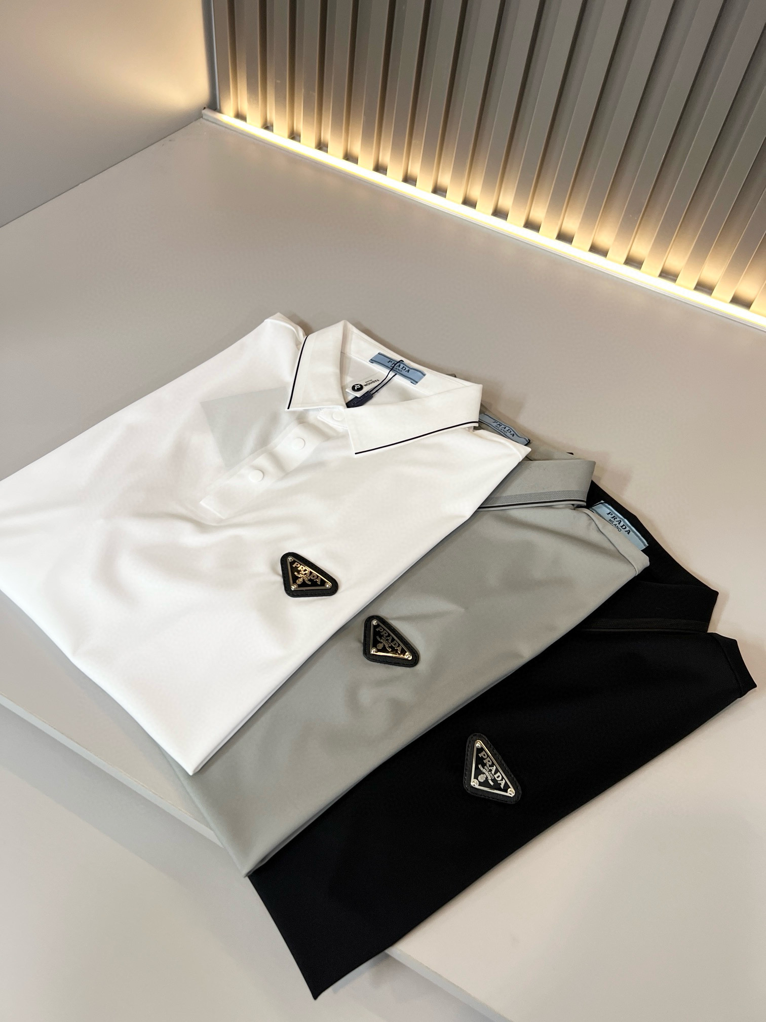 NO:481778,Prad*Pu*da 2025 spring and summer new classic element short-sleeved Polo shirt, a classic and elegant style, the kind that can be worn for ten years, you must collect a few pieces, and you must collect the rare and exquisite style!  A good taste!  It is 100% imported top-notch traceless ice silk fabrics that are important to no matter which season!  solid!  One of the best cottons recognized in the world!  The texture is perfect! The chest hardware logo badge design!  Perfectly enrich everyone's visual sense!  Make you feel clean and neat!  Fashionable and beautiful!  !  Only by wearing Prada's short-sleeved shirt can you know what is worth it!  PRADA has always been a quality life pursued by European aristocrats and upper class scholars. This simple and casual versatile T-shirt is a personal luxury item with fashionable colors. Luxury materials and rigorous craftsmanship are the main tools for PRADA to attract fans. The flat and stylish round neck is warm, comfortable and easy to wear. The black and white colors have their own tone and handsome, and it is truly a world-class style!  The design details of the brand are very exquisite, the upper body is light and stylish, and you have to buy the latest T-shirt every season. Faced with this consumable, it will save you the trouble of going out and outfitting. There are many letter T-shirts on the market, but this one is still rare to see. The streamlined tailoring and a light casual and artistic temperament give you enough spring to arrange the surface. Every person who pursues fashion, you may wish to try the size M-3XL, prada, prada, T-shirt, tees, t-shirt, alexander wang19860909Prad*普*达 2025春夏季新款经典元素短袖Polo衫,经典大方的款式,可以穿十年都还是流行的那种,你一定要收藏几件,难得精致极致的款,你一定要收！好品味的一件！重要到哪个季节都绕不开它百分百进口顶级无痕冰丝面料！结实！世界公认最好的棉之一！手感质感都极完美! 胸口五金logo徽章设计！完美的丰富大家的视觉感！让你感觉干净利落！时尚又好看！！穿上普拉达的这款短袖,才知道什么是人间太值得！PRADA一直都是欧洲贵族和上流社会雅士追求的品质生活这款简易休闲百搭T恤更是穿出个人奢侈的单品色彩时尚 奢侈的材质和严谨的工艺是PRADA圈粉的主要利器平整有型的圆领,版型温暖舒适好穿又好搭,黑白双色自带腔调和帅气,真正的一款打天下！品牌的设计细节十分考究,上身轻便有型,每季都要入手最新的T恤,面对这种消耗品,直接省了你出门穿搭的烦恼,市面上的字母T恤有很多,但这款还很难得一见了,信手拈来的流线剪裁,淡淡的休闲文艺气质,给足春日的排面,每个对时髦度有追求的你,都不妨上身一试尺码M-3XL,,prada,prada,T-shirt,tees，t-shirt,alexander wang,Men's clothing