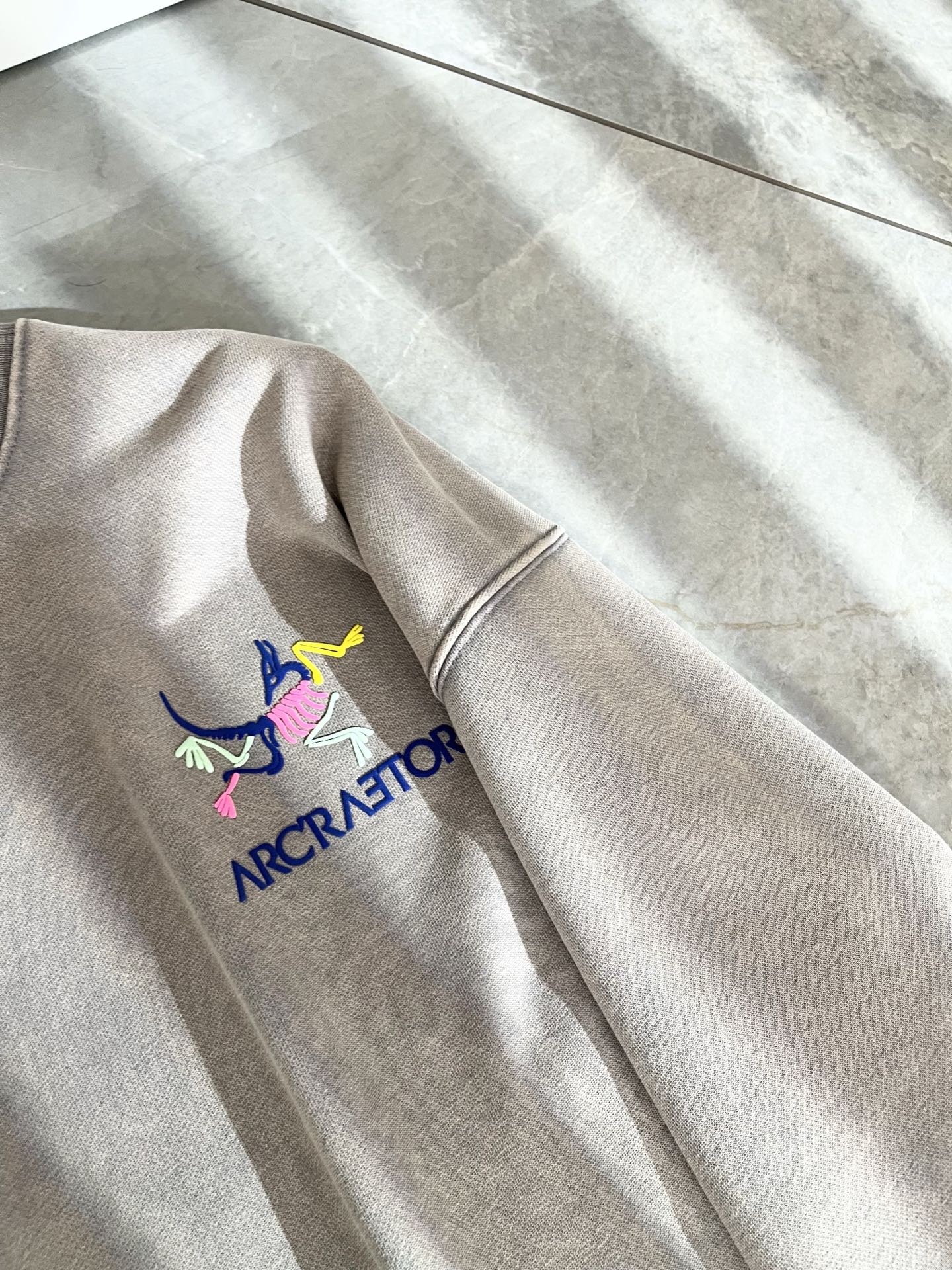 P265 ARCTER*X始*祖鸟 2025秋冬新款男女同款👫休闲卫衣，户外品牌可能大家第一想到的就是加拿大鹅、始祖鸟。给人一种标签试的感觉！除了在款式设计上颇有造诣之外，最明显或者说最为拿手的，应该就是在面料上的拥有更深独特见解跟造诣了。通过不断地结构研究和问题处理，在以面料独特研究为特征，仅凭这些就已经足以支撑其成为服装制造行业中，首屈可数的新标志品牌形象。此款采用纯棉材质！通过精工混纺纯棉之后的面料，手感细滑柔软，同时兼具自然美感跟舒适度。大身上版型裁剪简洁干净，面料上显现出了不一样朦胧的结构性美感来。独家开模定制而成，面料及其考验工人的技术，能做到平整服帖又不起皱！前后logo图案压胶设计！真的是很考验每位师傅的手工制作！使得整体干净利索，不留一丝线头。现在对于生活有所追求的男性也在生活中更为精致！尺码：S-2XL