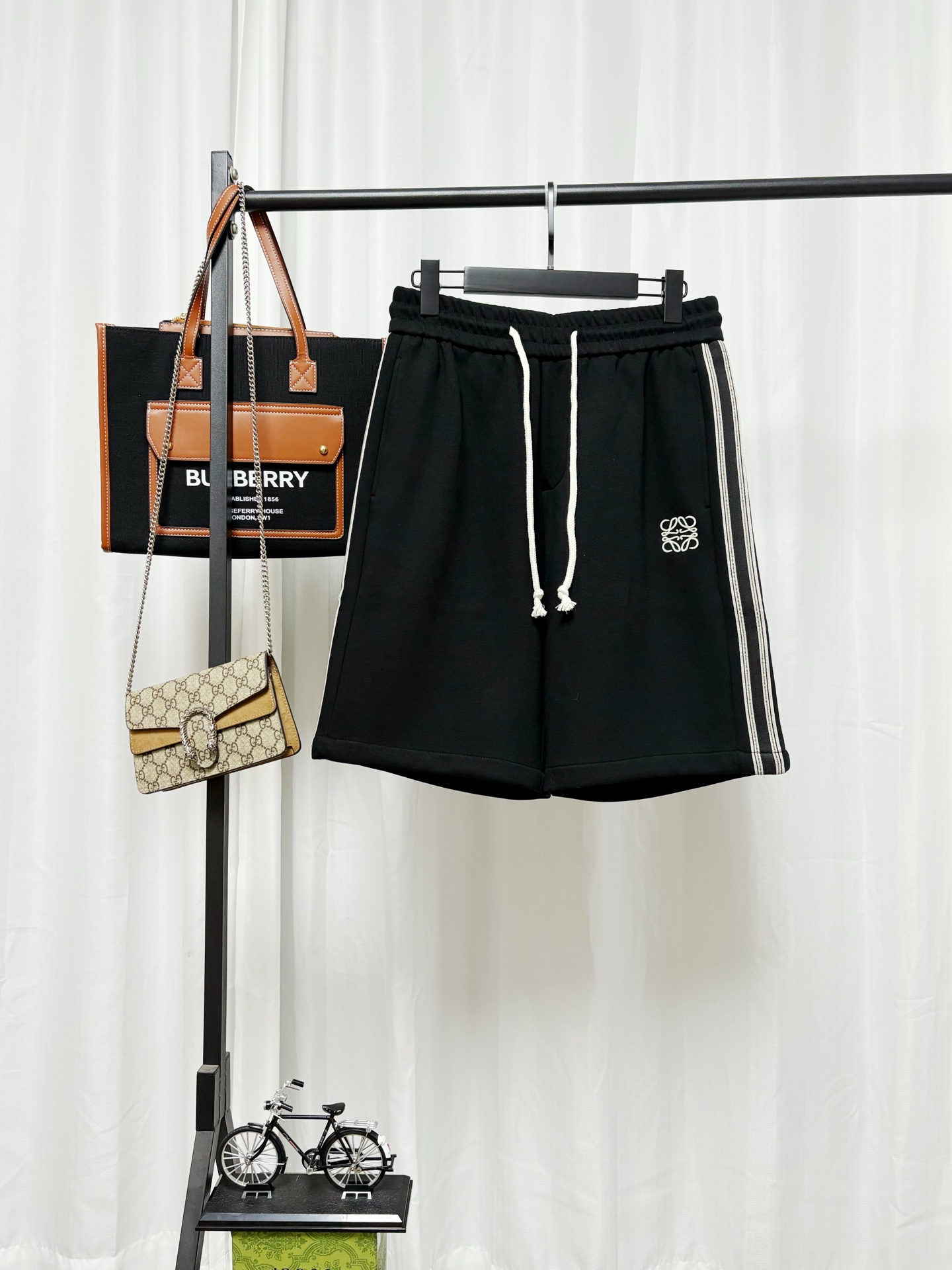 p140@✨ LOEWE 罗意威休闲运动卫短裤 品牌标志性的 Anagram 缠绕徽章logo，就是图中裤子左前方的刺绣图案，是罗意威最经典、最具辨识度的专属标识。 基础纯黑宽松直筒五分卫裤剪裁，不挑身材，慵懒休闲又自带贵气感，男女都好驾…