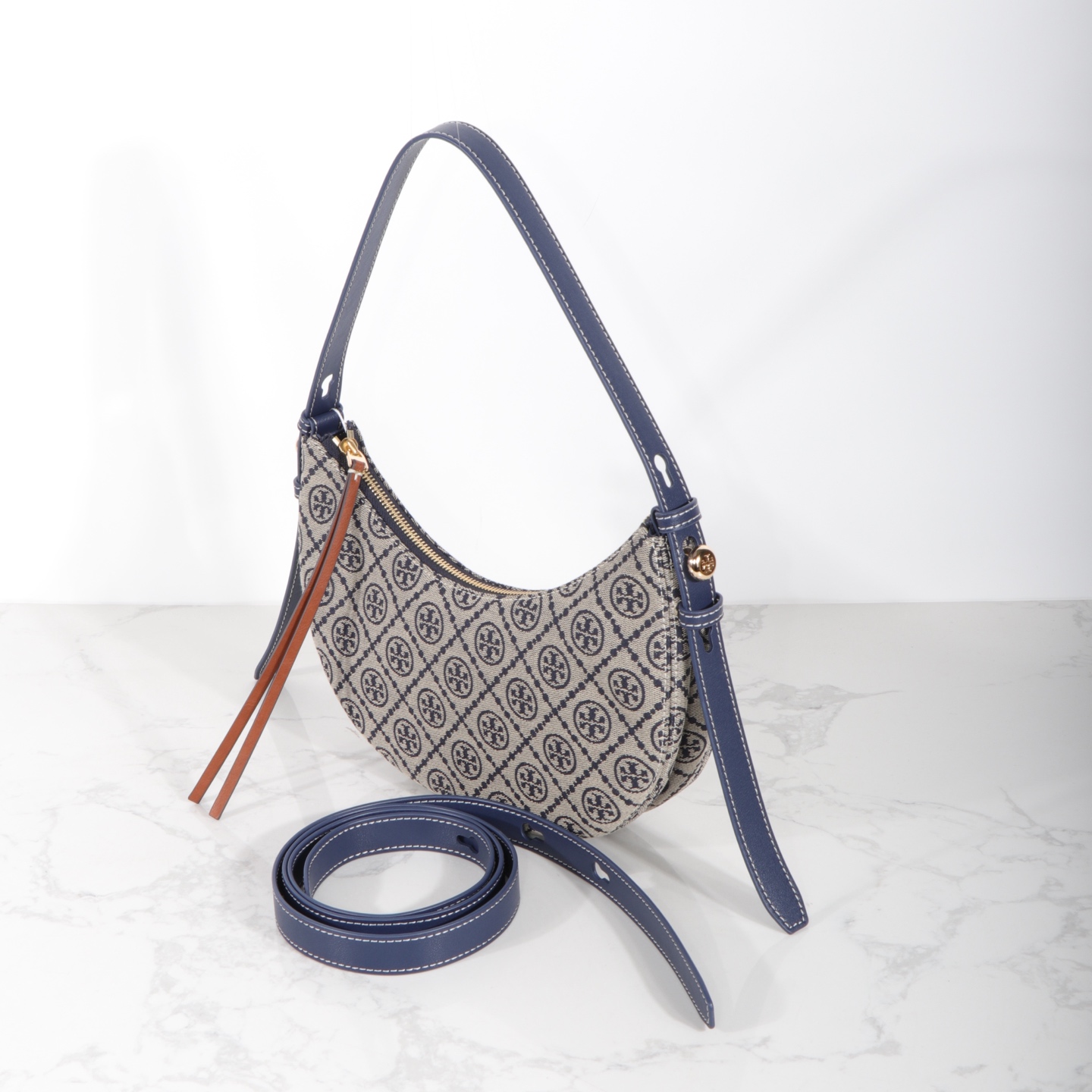 Tory Burch 编号178683 Romy新月包精选品牌标志性T Monogram提花图案与皮革饰边