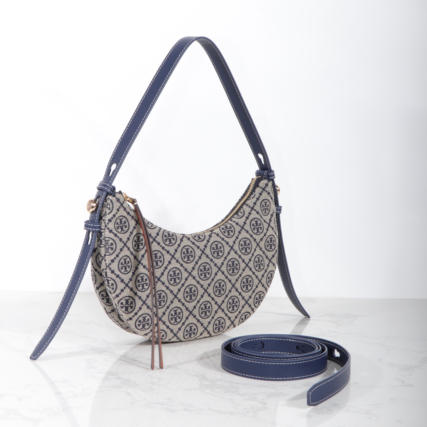 Tory Burch 编号178683 Romy新月包精选品牌标志性T Monogram提花图案与皮革饰边