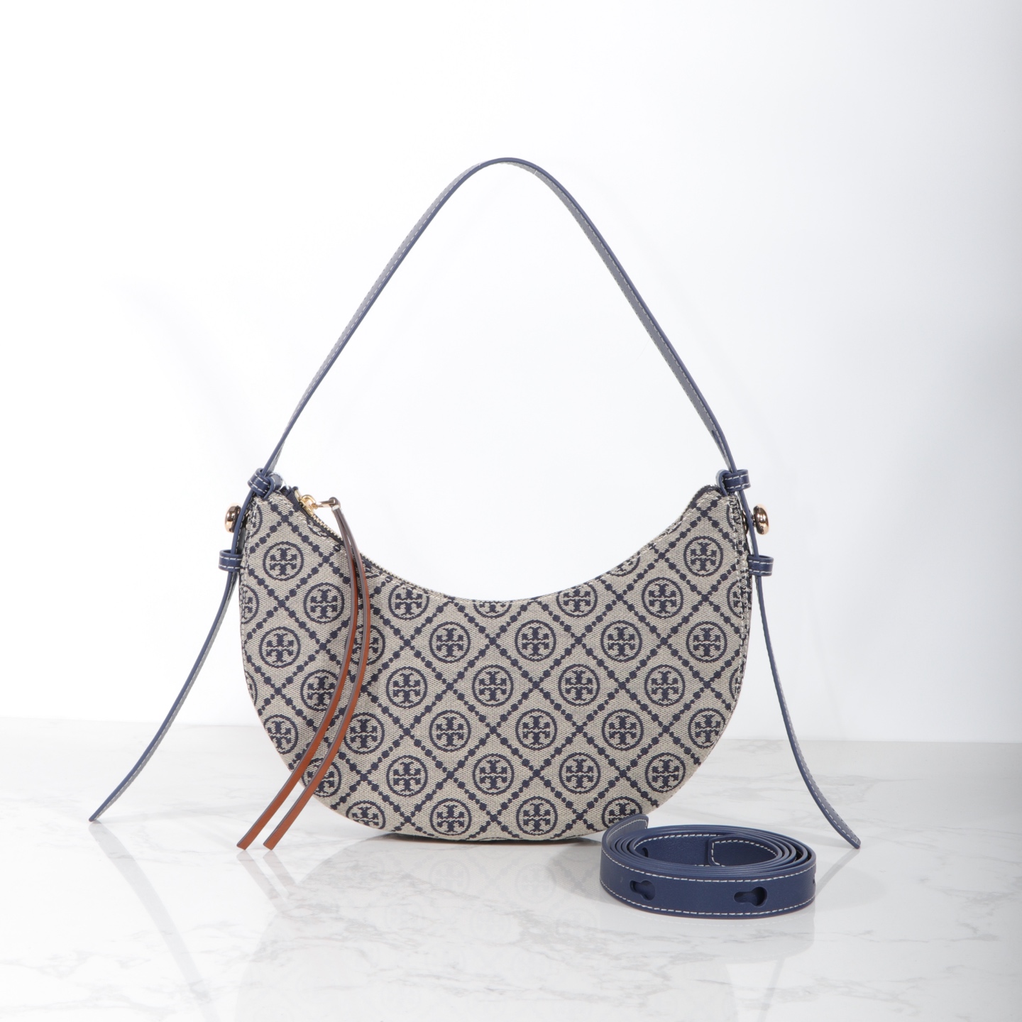 Tory Burch 编号178683 Romy新月包精选品牌标志性T Monogram提花图案与皮革饰边
