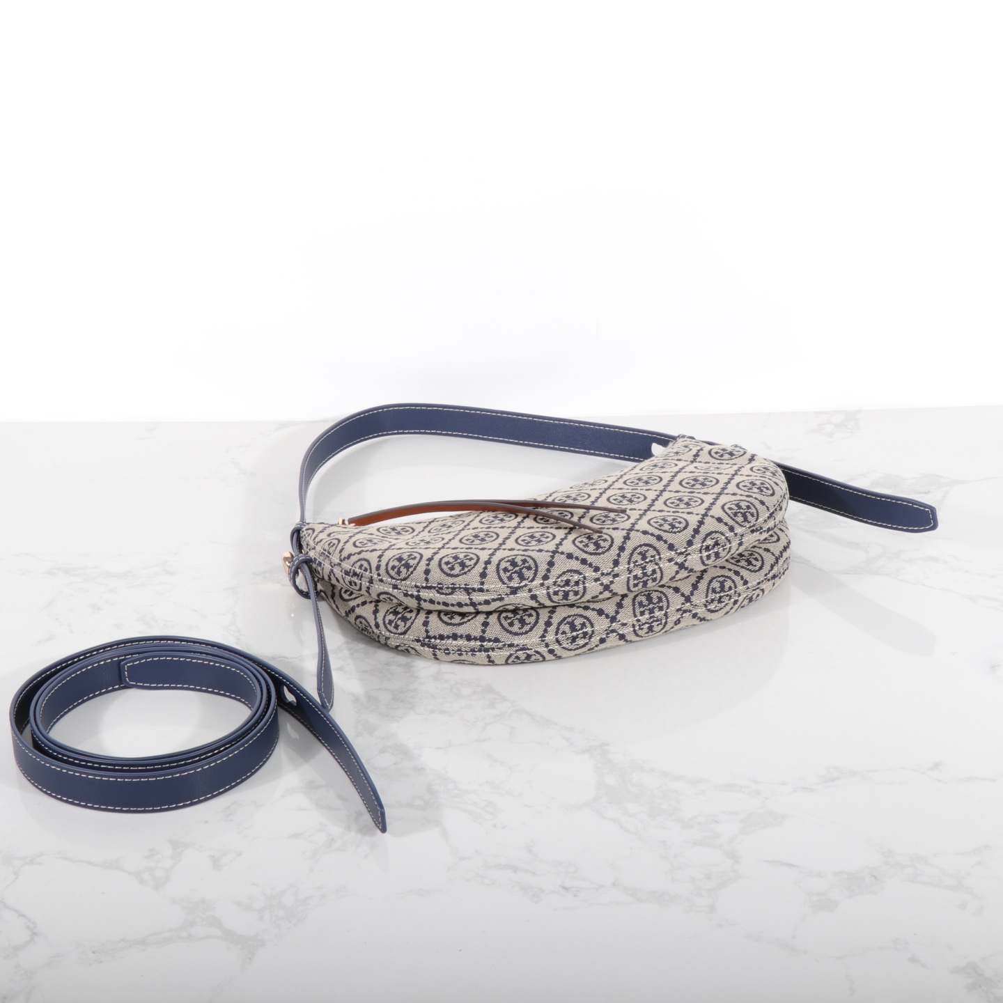 Tory Burch 编号178683 Romy新月包精选品牌标志性T Monogram提花图案与皮革饰边