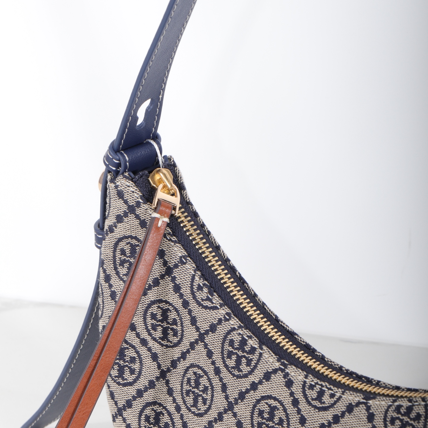 Tory Burch 编号178683 Romy新月包精选品牌标志性T Monogram提花图案与皮革饰边