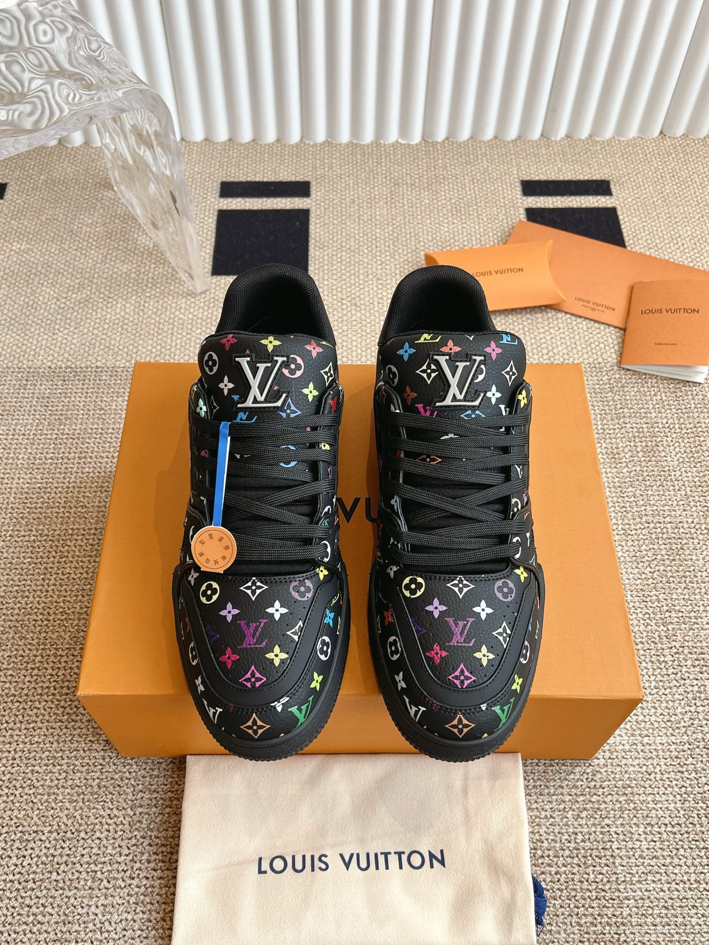 现货秒发\nSQLV xTM IV TRAINER 路易威登x 村上隆联名运动鞋‼\n      本款 LV Trainer 运动鞋选用粒面牛皮革演绎路易威登 x 村上隆再版系列的鲜明美学，以全幅 Monogram 图案彰显缤纷巧思。复古运动风格鞋面点缀手写体路易威登标识，后部  数字追溯品牌诞生的  年。\n\n鞋面：粒面牛皮革\n大底：橡胶外底点缀 Monogram 花卉\n码数：-