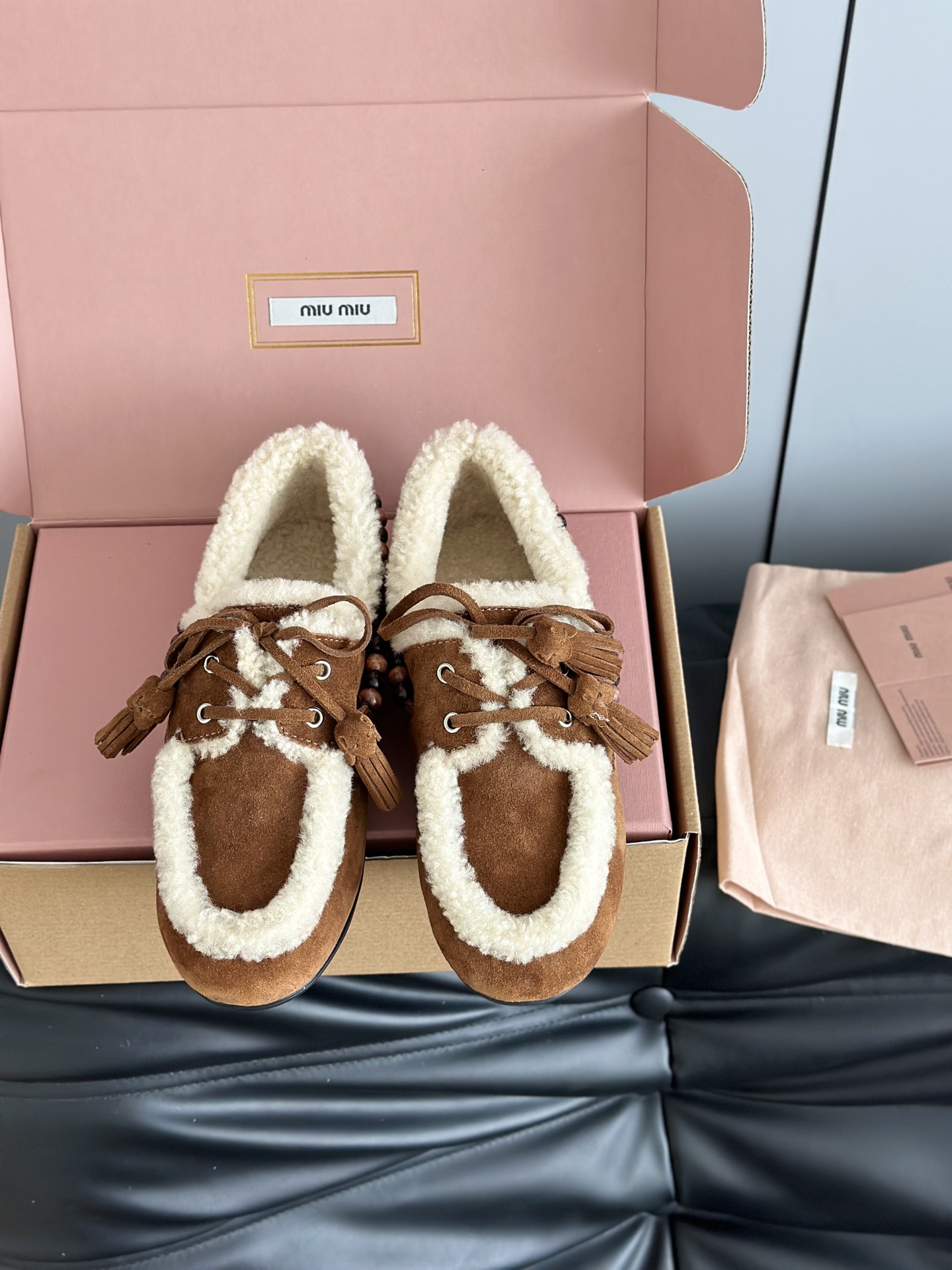 NO:614006,Miumi*25 new lamb wool tassel loafers, deck shoes, are available in retro colors such as brown and dark brown. The edges and mouth of the shoes are decorated with white plush, which creates a sharp contrast, keeping warm and adding a cute atmosphere. There are wooden beading decorations on the sides of the shoes, and tassel elements on the shoelaces, giving it a full retro feel. The shoe shape is a classic loafer silhouette, and the retro feel of the warm plush shoes collides with the softness of the skirt to create a unique style.  The upper is made of original cow suede, the lining is pure wool, the original molded outsole is Size 35-40 (customized for 40, non-returnable), loafers, fur shoes, miumiu, loafers, skirts19860909Miumi*25新款羊羔毛流苏乐福鞋 deck shoes 羊毛乐福鞋,有棕色、深棕色等复古色调可选；鞋边和鞋口点缀白色毛绒,形成鲜明对比,既保暖又增添可爱氛围.鞋侧有木质串珠装饰,鞋带处搭配流苏元素,复古感拉满；鞋型是经典乐福鞋轮廓,保暖毛绒鞋的复古感与裙装的柔美碰撞出独特风格. 鞋面采用原版牛反绒,内里纯羊毛,原版开模大底 Size35-40（40定制不退换）,乐福鞋毛毛鞋,miumiu,loafers,skirts,Women's Shoes