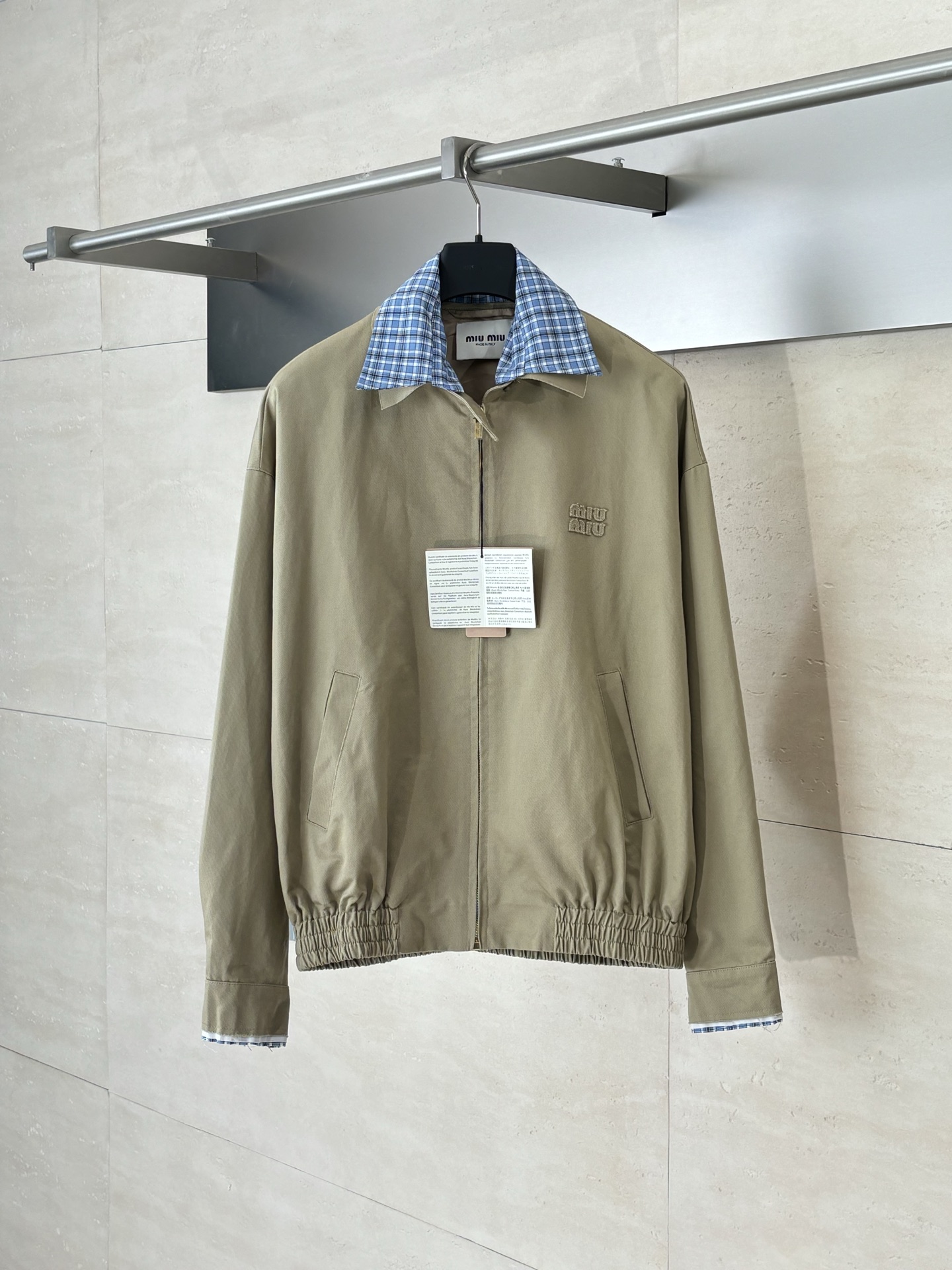 NO:530327,Miumi*/Miao Miu 25SS plaid fake two-piece jacket  Fixed weaving and dyeing high-substantiated textiles give the fabric a stiff bone and delicate texture touch. The twill structure ensures wrinkle resistance and durability, and at the same time, it enhances the surface texture through shiny gloss finishing, echoing the modern urban functional aesthetics. A 19mm-level silk blended lining is selected to fit the main fabric with electrostatic overlay technology to achieve a seamless integrated structure. The silk lining not only provides skin-friendly and breathable, but also strengthens the difference in the inner and outer layers through contrasting gloss, hiding a low-key luxury. Composite splicing design, the neckline and cuffs are spliced ​​with blue plaid, which achieves precise grid alignment through laser cutting and edging. The splicing parts are connected by hidden buried clamp sewing, and the edges are treated with 0.3cm antique burrs to simulate the retro effect of natural wear, and at the same time form a rough and exquisite material dialogue with the main fabric. SizeS/M/L,,miumiu,jackets  & coats,jackets & coats,alexander wang19860909Miumi*/缪缪 25SS 格纹假两件夹克外套 定织定染高支数斜纹纺织,赋予面料硬挺的骨骼感与细腻的肌理触感.斜纹结构确保抗皱性与耐久度,同时通过微光泽后整理提升表面质感,呼应现代都市机能美学.选用19姆米级丝绸混纺内衬,以静电覆合技术贴合主体面料,实现无缝一体结构.丝质内里不仅提供亲肤透气性,更通过对比光泽强化内外层次差异,暗藏低调奢华感.复合式拼接设计,领口、袖口采用蓝格纹拼接设计,通过激光裁切包边工艺实现精准对格.拼接部位以隐藏式埋夹缝制衔接,边缘做0.3cm仿旧毛边处理,模拟自然磨损的复古效果,同时与主面料形成粗犷与精致的材质对话.  SizeS/M/L,,miumiu,jackets & coats,jackets & coats,alexander wang,Men's clothing