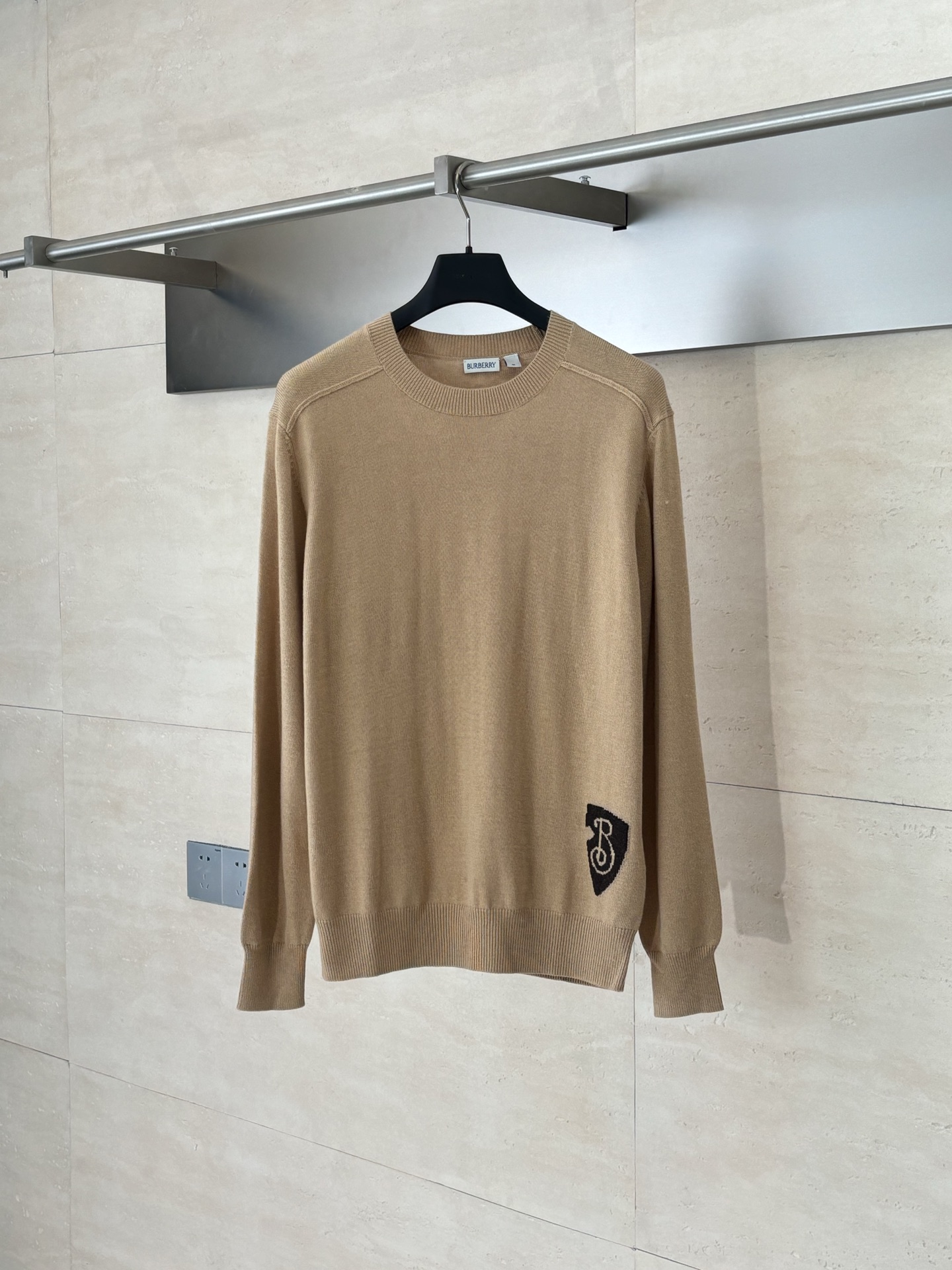 NO:530331,Burberr*/Burberry Shield inlay knitted round-neck pullover sweater is made of customized wool fabric, wool, and hem jacquard technology is made of Burberry classic B-shaped shield as the core element. The pattern is woven by precision jacquard loom, with clear and neat lines and full of three-dimensional sense. The jacquard part is integrated with the brand letter logo, which not only retains the retro charm but also injects a modern street feeling. The side seams are positioned by infrared to ensure accurate pattern splicing, custom auxiliary materials, complete three-marks SizeS/M/L,,burberry,burberry,sweaters,alexander wang19860909Burberr*/巴宝莉 盾牌嵌花针织圆领套头毛衣 采用定制羊毛面料,羊毛,下摆提花工艺以Burberry经典B字盾牌为核心元素,图案通过精密提花织机编织,线条清晰利落,立体感十足.提花部分融入品牌字母标识,既保留复古韵味,又注入现代街头感,侧缝线采用红外线定位,确保图案拼接精准对齐,定制辅料,三标齐全 SizeS/M/L,,burberry,burberry,sweaters,alexander wang,Men's clothing