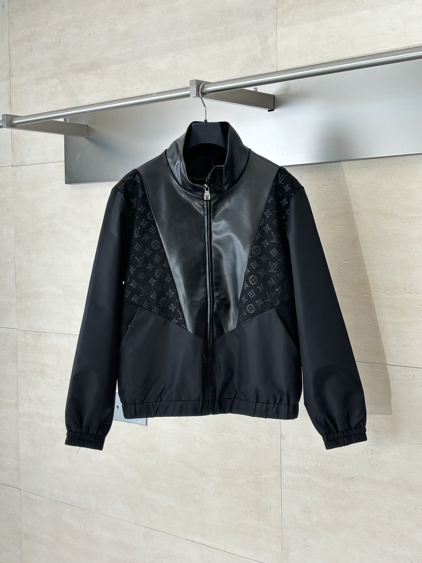 NO:530344,1V/Louis Presbyterian patch leather jacket adopts innovative material splicing technology, cleverly combining technology-sensitive nylon fabric with luxurious sheepskin leather. The body of the garment is made of nylon material to ensure lightness and breathability; soft sheepskin leather is incorporated into details such as the cuffs, collar and front, and embellished with Monogram embossed suede leather inlay to show the classic brand elements. The lining is made of 65 viscose fiber and 35 cotton blend fabric, which brings a comfortable and skin-friendly experience. The turtle collar design is matched with elastic cuffs and hem, which is both windproof and warm and ensures freedom of movement. The side zippers are easy to put on and off, and the practical pockets on both sides add functionality. The overall standard style is cut, and through the texture comparison of different materials, the sports and leisure style is perfectly integrated with high-end leather craftsmanship to create a seasonal change item that combines practicality and luxury. SizeS/M/L/XL,,louis  vuitton,jackets & coats,leather jacket,sheepskin,alexander wang198609091V/路易 老花贴布拼皮皮衣外套 采用创新材质拼接工艺,将科技感锦纶面料与奢华羊皮革巧妙结合.衣身主体选用锦纶材质,确保轻盈透气；袖口、领部及前襟等细节处融入柔软羊皮革,并点缀Monogram压纹绒面皮革嵌饰,展现品牌经典元素.内衬采用65粘胶纤维与35棉混纺面料,带来舒适亲肤体验.高领设计搭配弹力袖口及下摆,既防风保暖又确保活动自如.侧边拉链开合方便穿脱,两侧实用口袋增添功能性.整体采用标准版型剪裁,通过不同材质的质感对比,将运动休闲风格与高级皮革工艺完美融合,打造兼具实用性与奢华感的换季单品. SizeS/M/L/XL,,louis vuitton,jackets & coats,leather jacket,sheepskin,alexander wang,Men's clothing