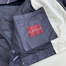 Gucc*/古驰 25SS秋冬新款假两件连帽尼龙风衣夹克冷调金属边框与暖黄灯带交织,衬托夹克的低调光泽。 Gucc*/古驰 25SS秋冬新款假两件连帽尼龙风衣夹克冷调金属边框与暖黄灯带交织,衬托夹克的低调光泽。