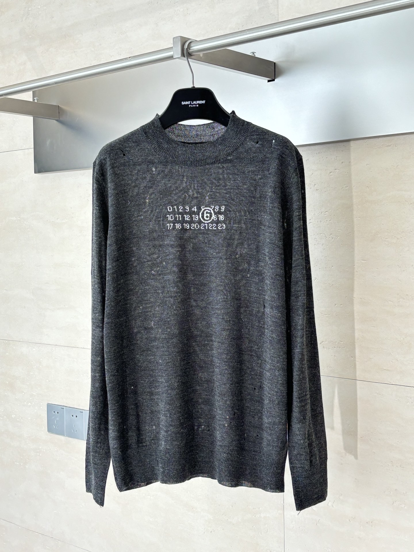 NO:539833,Martin Margiel*/Martin Margiel*/Martin Margiel* 25FW MM6 Destruction Jacquard Wool Blend Sweater Special Gray Yarn, whose gray color is not an ordinary color, but a special gray yarn specially designed for destruction. The chest pattern adopts precision jacquard technology, which is woven at one time, rather than post-printing and dyeing. All destruction treatments are done by craftsmen after the sweater is completely woven into shape. This is essentially different from the simple method of 'breaking first and weaving', which requires craftsmen to have an extreme understanding of the tension, elasticity and dispersion of the knitted structure. SizeS/M/L,,masion margiela,masion margiela,sweaters,alexander wang19860909Martin Margiel*/马吉拉 25FW MM6破坏提花羊毛混纺毛衣 定纺特殊灰色纱线,其灰色绝非普通色号,而是专门定纺的特殊灰度纱线.胸前图案采用精密提花工艺,一次性织就,而非后期印染. 所有破坏处理都是在毛衣完全织造成型后,由工匠手工完成的.这与“先破再织”的简单方式有本质区别,要求工匠对针织结构的张力、弹性和脱散性有极致理解. SizeS/M/L,,masion margiela,masion margiela,sweaters,alexander wang,Men's clothing