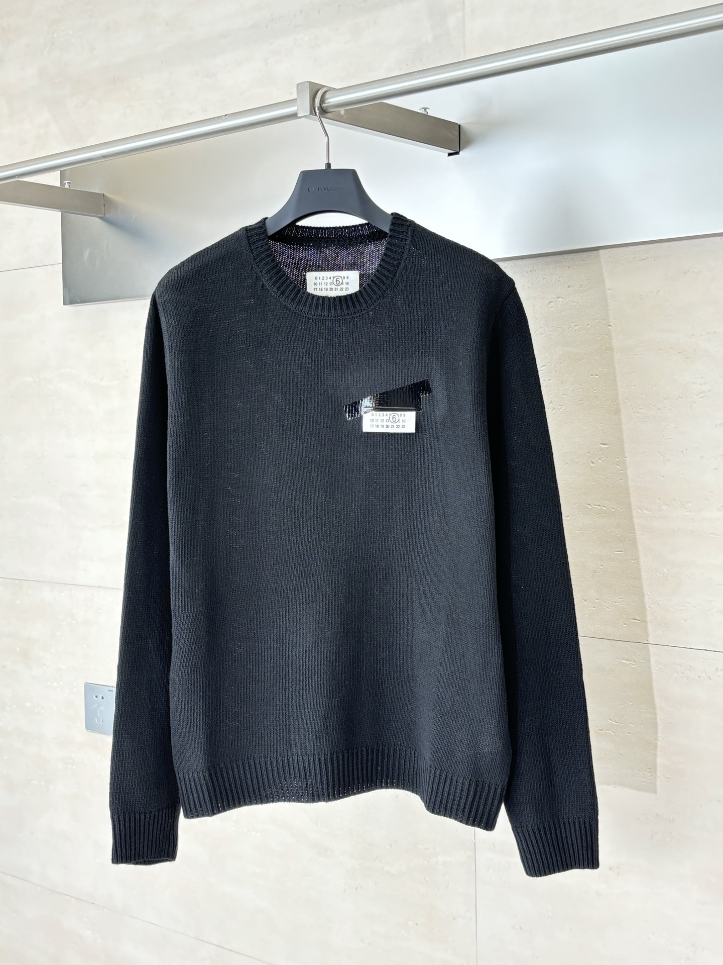 NO:539836,Martin Margiel*/Martin Margiel*/Martin Margiel* 25FW MM6 tape label wool blend sweater The main body is made of high-subsidized, high-density wool blend yarn. The custom multi-layer engraving film is made of hot painting technology on the chest. The hot painting film material used is specially treated to give it a light gloss of PVC texture, perfectly simulates the visual effect of black tape covering the paper label. Its thickness and flexibility are accurately calculated to ensure that it can naturally bend with the fabric instead of cracking when worn. SizeS/M/L,,masion margiela,masion margiela,sweaters,alexander wang19860909Martin Margiel*/马吉拉 25FW MM6胶带标签羊毛混纺毛衣 主体采用高支数、高密度的羊毛混纺纱线精纺而成. 胸前定制多层刻字膜烫画工艺,所使用的烫画膜料本身经过特殊处理,使其呈现出PVC质感的微光泽,完美模拟了黑色胶带覆盖在纸张标签上的视觉效果.其厚度和柔韧性经过精确计算,确保在穿着时能随面料自然弯曲而非开裂. SizeS/M/L,,masion margiela,masion margiela,sweaters,alexander wang,Men's clothing