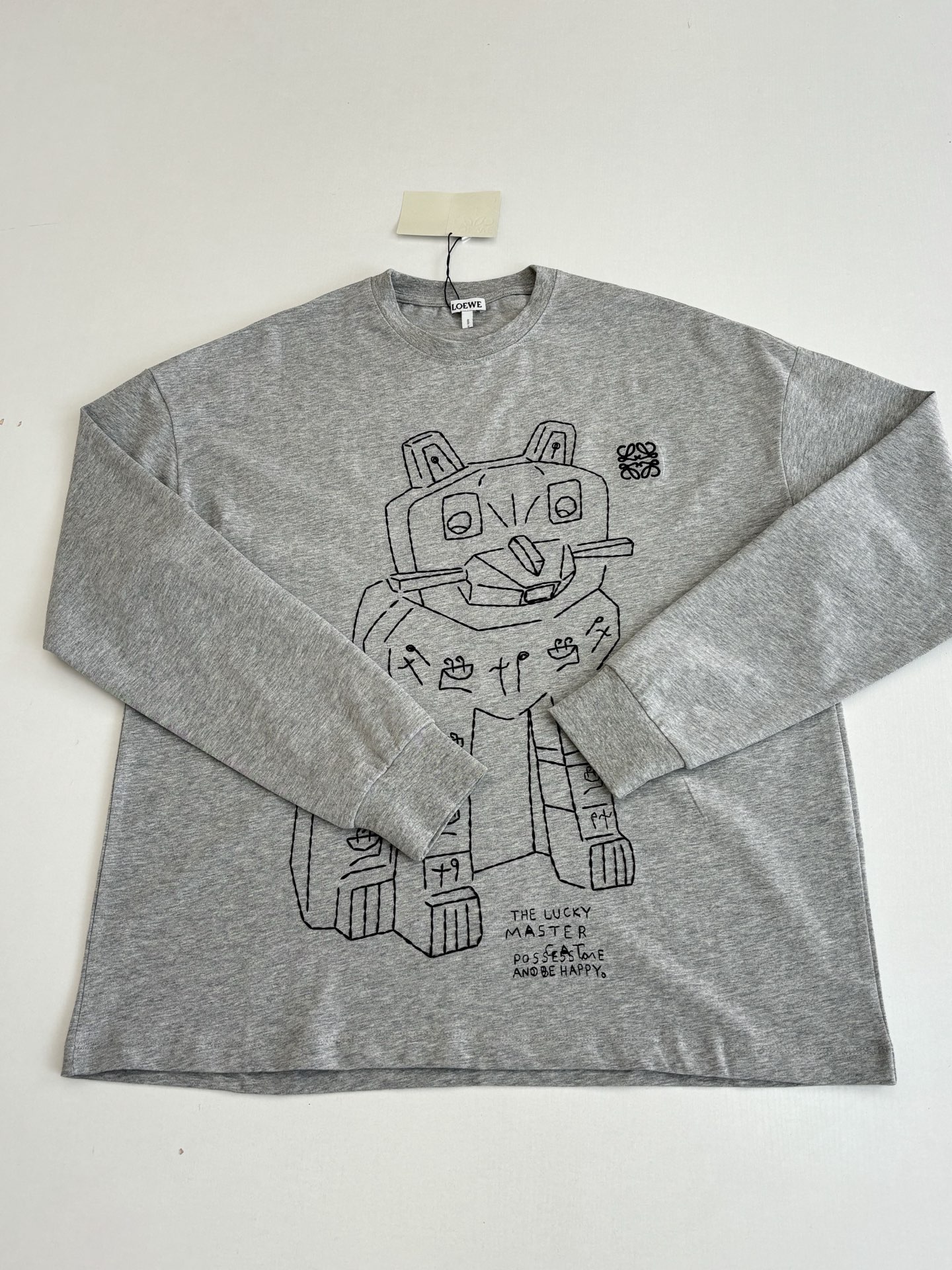 P145
Loew*/罗意威 SS26 Louis Wain 联名灰色宽松长袖T恤

进口棉质面料为基底，上身舒适透气 标志性的oversize宽松廓形与基础圆领设计 兼顾舒适体感与极简穿搭适配性

Size：S/M/L/XL