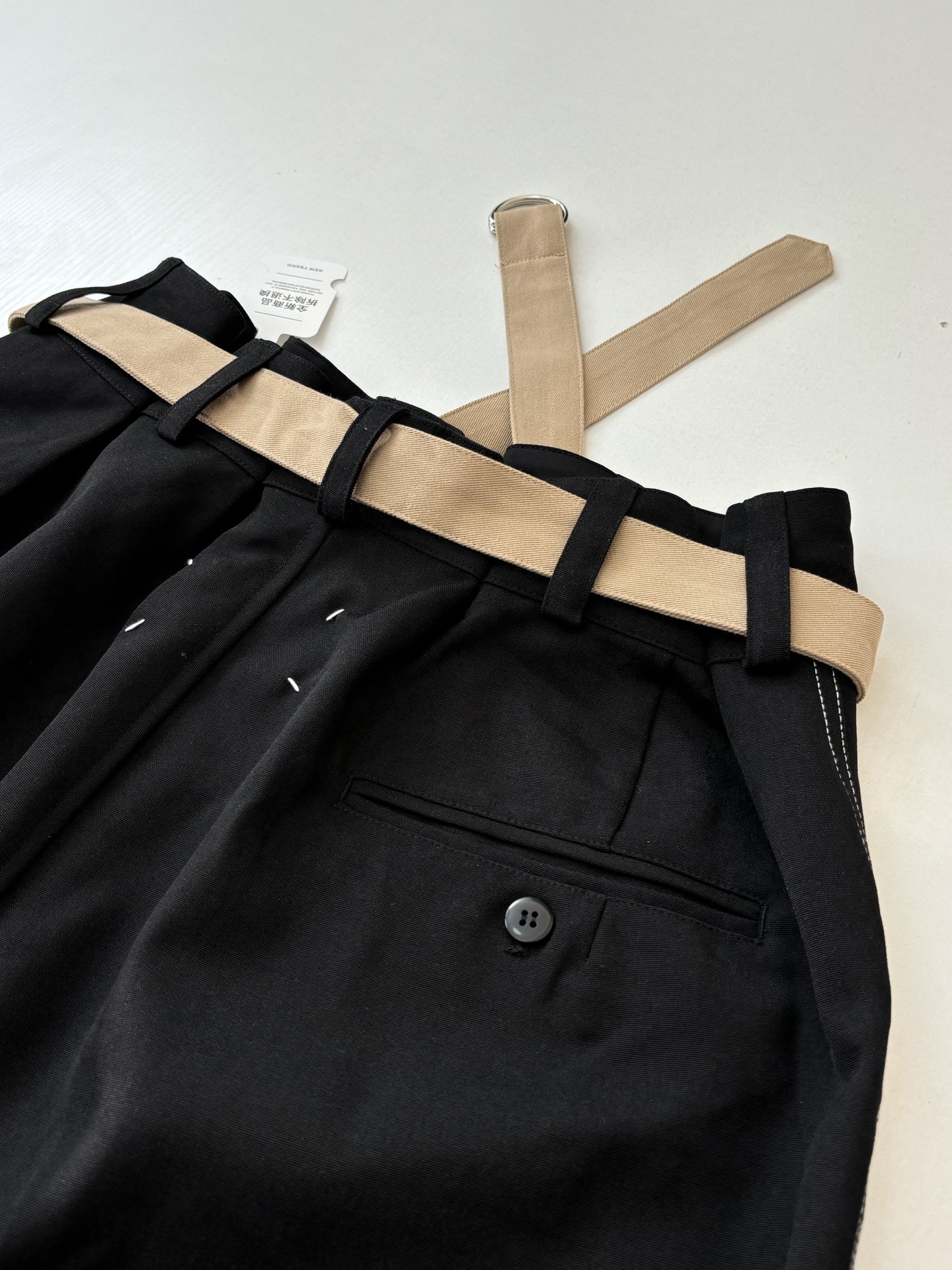 P235
Maison Margiel*/马吉拉 MM6 腰带明线直筒休闲裤

定制珀光细梭羊毛丝绒料 轻盈柔软 舒适贴肤 以一袭纯粹黑色 勾勒现代男士的沉稳格调 一条隐匿的亮纱嵌线藏于侧缝 视觉上纵向拉伸腿长 悄然打破黑色的沉寂 后幅以标志性马吉拉品牌四角缝线彰显品牌风范  隐于众 显于智腰带与面料的光影交织 让每一寸肌理都诉说着低调的奢华 腰带轻系 柔中带韧 勾勒出松弛与精致的平衡  让每一步行走都成为流动的诗意，人体学立体裁剪  回归传统工艺手法 通过分割 折叠 抽缩 拉展技术手法 所谓慢工出细活 是对材料的尊重 对手感的追求 做工复杂 繁琐 时效慢 损耗高，每件皆由师傅纯手工缝标 可以确保位置和间距的准确率 手缝工艺更能体现匠人的精湛技艺和对细节的把控。整体走线平直细腻，面料舒适柔软，颜色一致无色差 能与同款搭配营造时尚造型，驾驭各种场合，定制辅料，三标齐全，男女同款！

Size：S/M/L/XL