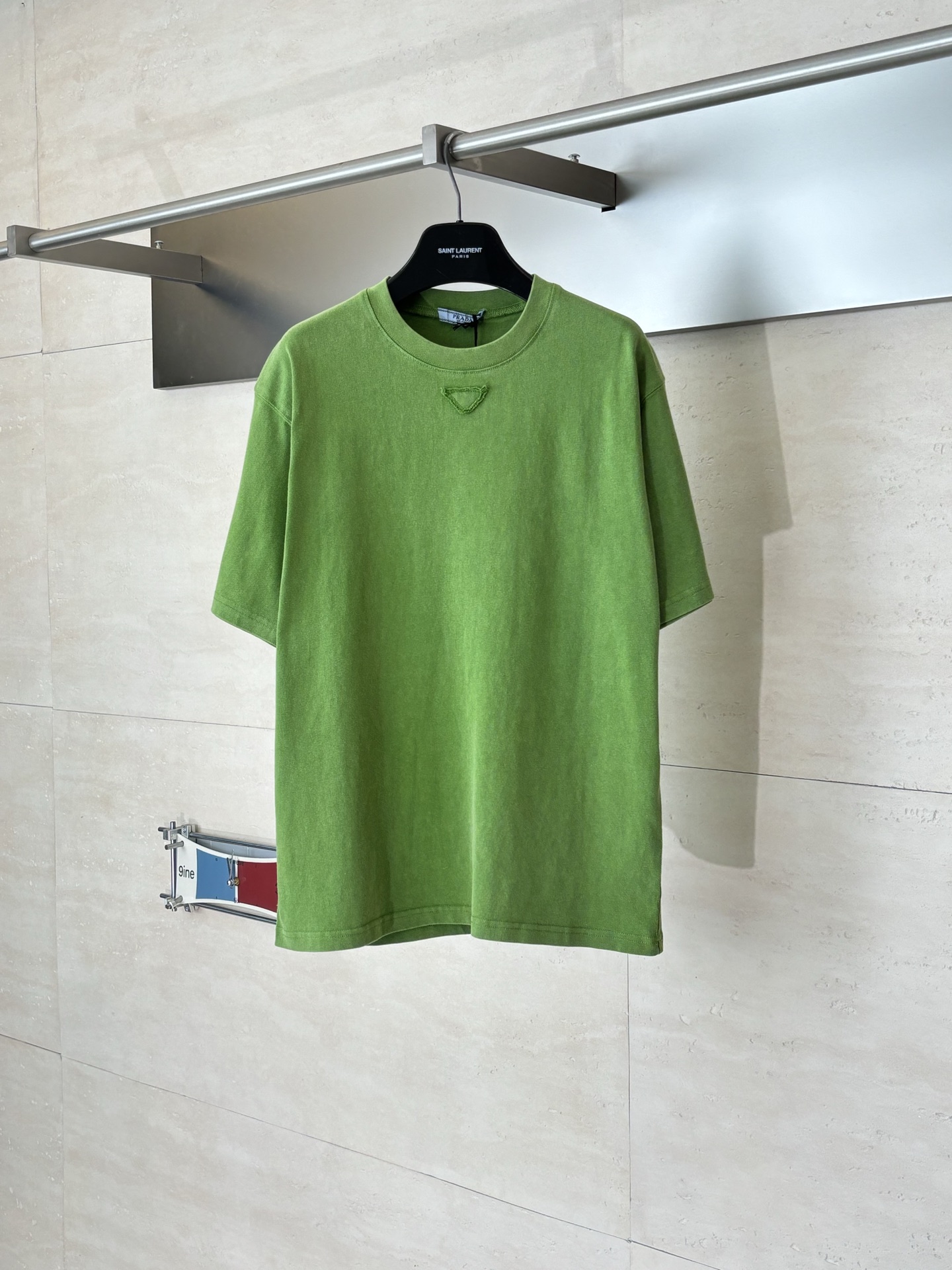 P145 Prad*/Prada SS26 Camiseta de manga corta con logo triangular en verde fruta desgastado. El clásico logotipo bordad…