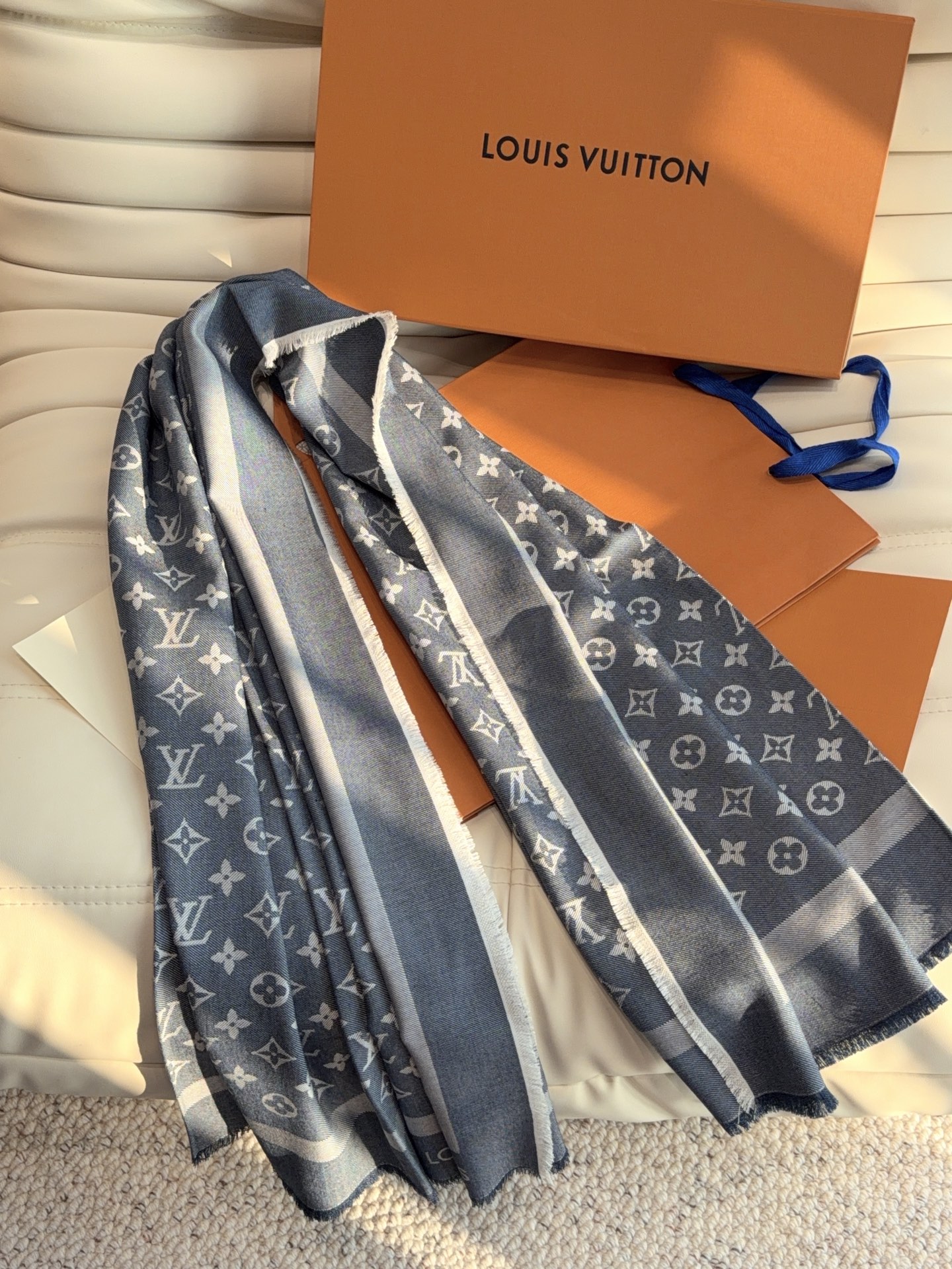 LV全新 Petit Louis 披肩以提花工艺和双色纱线织就 Monogram 图案。轻软丝绒混纺裁出小幅尺寸，搭配流