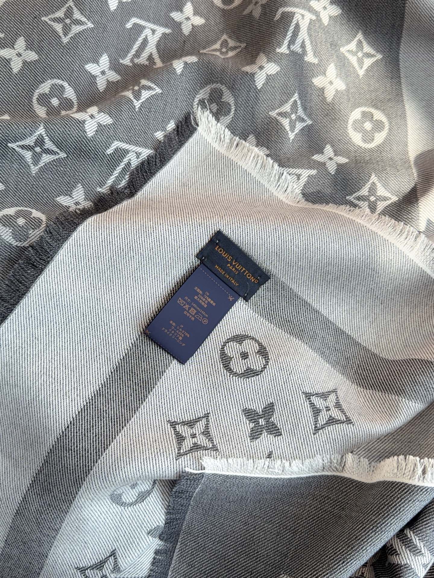 LV全新 Petit Louis 披肩以提花工艺和双色纱线织就 Monogram 图案。轻软丝绒混纺裁出小幅尺寸，搭配流
