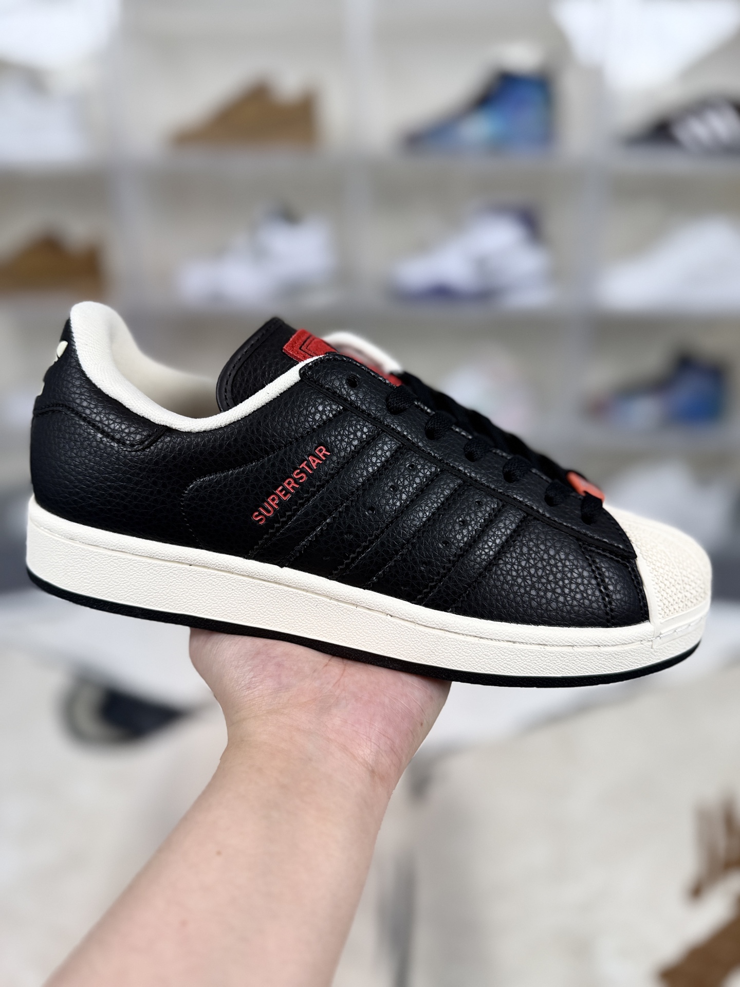 本地💰150   
▪️D版纯原
adidas originals SUPERSTAR Paris 百搭舒适 耐磨 低帮 板鞋 男女同款 黑红
▪️尺码：35.5-45（35⅔ 36 36⅔ 37⅓ 38 38⅔ 39⅓ 40 40⅔ 41⅓ 42 42⅔ 43⅓ 44 45⅓）
▪️货号：JQ3223
▪️Superstar系列以贝壳头设计著称，这一标志性元素使其在众多鞋款中脱颖而出。贝壳头不仅具有防撞和保护脚尖的作用，还成为了时尚界的经典符号。作为阿迪达斯经典系列的一部分，Superstar鞋侧常常饰有三叶草标志，彰显品牌身份与品质保证。鞋面采用优质皮革，质感高级且耐磨耐穿。柔软橡胶底则提供了良好的缓震效果和抓地力。Superstar板鞋以其舒适的穿着体验而著称。柔软橡胶底和合理的内部空间设计，使得长时间穿着也不会感到疲劳。简约复古的鞋型搭配贝壳头设计，使得Superstar成为一款百搭鞋款。无论是搭配牛仔裤、休闲裤还是裙子，都能轻松驾驭各种风格。采用优质材质和精湛工艺打造，Superstar板鞋具有出色的耐用性和耐磨性，能够陪伴消费者度过漫长的时光。自诞生以来，Superstar逐渐成为街头潮流文化的代表之一。众多潮人、明星和设计师都钟爱这款鞋款，纷纷将其纳入自己的穿搭中。