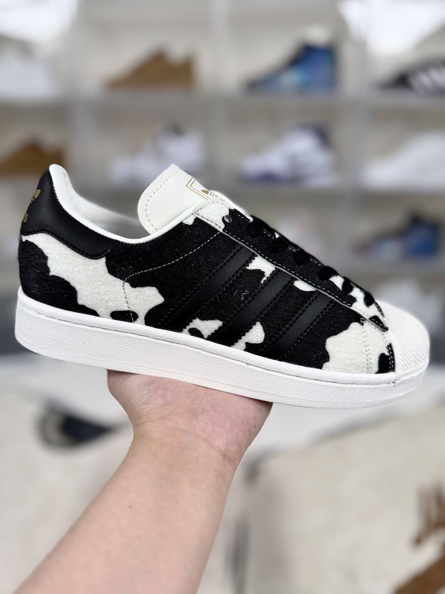 本地💰150   
▪️D版纯原
adidas originals SUPERSTAR Cow Fur 舒适百搭 低帮 板鞋 男女同款 黑白奶牛
▪️尺码：35.5-45（35⅔ 36 36⅔ 37⅓ 38 38⅔ 39⅓ 40 40⅔ 41⅓ 42 42⅔ 43⅓ 44 45⅓）
▪️货号：J
▪️Superstar系列以贝壳头设计著称，这一标志性元素使其在众多鞋款中脱颖而出。贝壳头不仅具有防撞和保护脚尖的作用，还成为了时尚界的经典符号。作为阿迪达斯经典系列的一部分，Superstar鞋侧常常饰有三叶草标志，彰显品牌身份与品质保证。鞋面采用优质皮革，质感高级且耐磨耐穿。柔软橡胶底则提供了良好的缓震效果和抓地力。Superstar板鞋以其舒适的穿着体验而著称。柔软橡胶底和合理的内部空间设计，使得长时间穿着也不会感到疲劳。简约复古的鞋型搭配贝壳头设计，使得Superstar成为一款百搭鞋款。无论是搭配牛仔裤、休闲裤还是裙子，都能轻松驾驭各种风格。采用优质材质和精湛工艺打造，Superstar板鞋具有出色的耐用性和耐磨性，能够陪伴消费者度过漫长的时光。自诞生以来，Superstar逐渐成为街头潮流文化的代表之一。众多潮人、明星和设计师都钟爱这款鞋款，纷纷将其纳入自己的穿搭中。