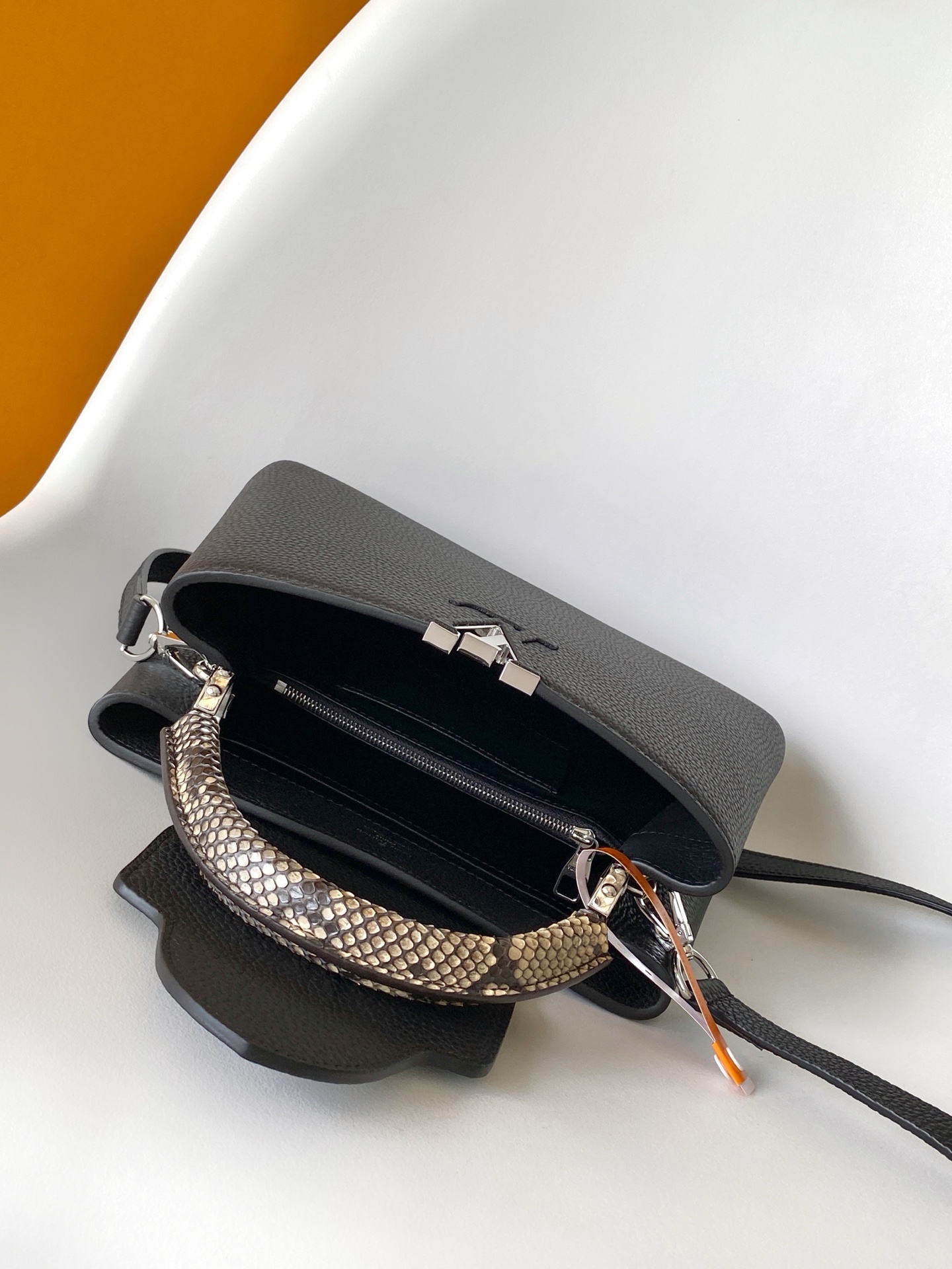 p950💰N85515白色 N85514黑色 N85513黑色 白丽 N85516黑色 N85517 灰色 特级原厂 动态163 2024 夏季款 Capucines 迷你手袋取材 Taurillon 牛皮革，再以华美蟒蛇皮革包裹手柄及 LV 字母，为标志性设计融入异域风情。可拆卸肩带实现舒适肩背或斜挎体验。
21.0 x 13.6 x 8.0 厘米 (长 x 高 x 宽)
27.0 x 17.3 x 9.0 厘米 (长 x 高 x 宽)
	•	Taurillon 牛皮革
	•	Taurillon 牛皮革和蟒蛇皮革饰边
	•	牛皮革内衬
	•	金属件
	•	翻盖可置于内侧或外侧 
	•	内隔层配有拉链袋和贴袋
	•	金属底钉
	•	肩带：可拆卸，可调节
	•	包带半长：46.5 厘米
	•	包带半长可调至：54.0 厘米
	•	手柄：单手柄