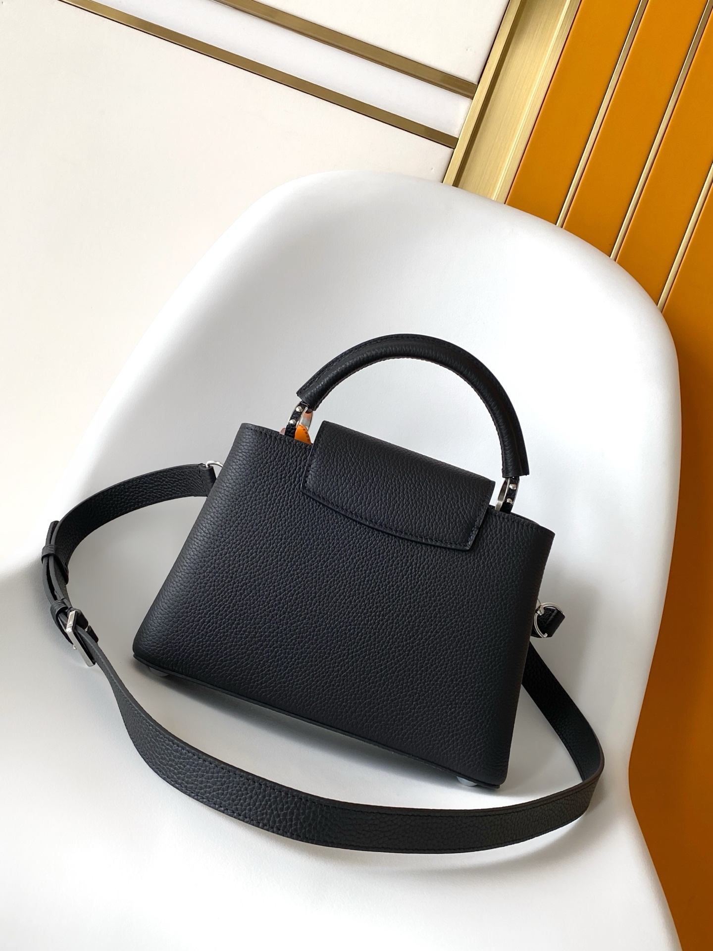 p1180💰M27035蓝色M27034紫红 M27039粉色 M26507西瓜红 M26351黑色白丽 M26814黑色 M26345米白横版Capucines Mini是一款适用于日间与夜晚场合的精致配饰。它采用由品牌珠宝启发的无限链设计，材质选用本季标志性深紫色色调的塔维尔隆皮革制成。双重镀锌五金细节，包括以放射状排列，反射光线的太阳纹工艺呈现的标志性LV首字母，增添了几分奢华感。可拆卸的肩带设计，让你既能将其作为肩包佩戴，斜挎于一侧肩头，亦可手提于顶部手柄处。
21x13.6x8厘米(长x高x宽)
27 x 17.3 x 9 (厘米) ((长 x 高 x 宽)
22 x 12 x 8 (厘米) ((长 x 高 x 宽)
横版白色
。托里昂皮革.Toryong皮革饰边。牛皮内衬
。金色与银色五金件
两种佩戴方式：可将翻盖收起或拉出。带一个平口袋的分隔内衬。底部四金属底座，用于保护
。存储：智能手机，Capucines紧凑钱包，钥匙。肩带：可拆卸，长度可调节
。肩背时最小肩带长度：46.5厘米
。肩背时最大肩带长度：54.0厘米手柄：简约