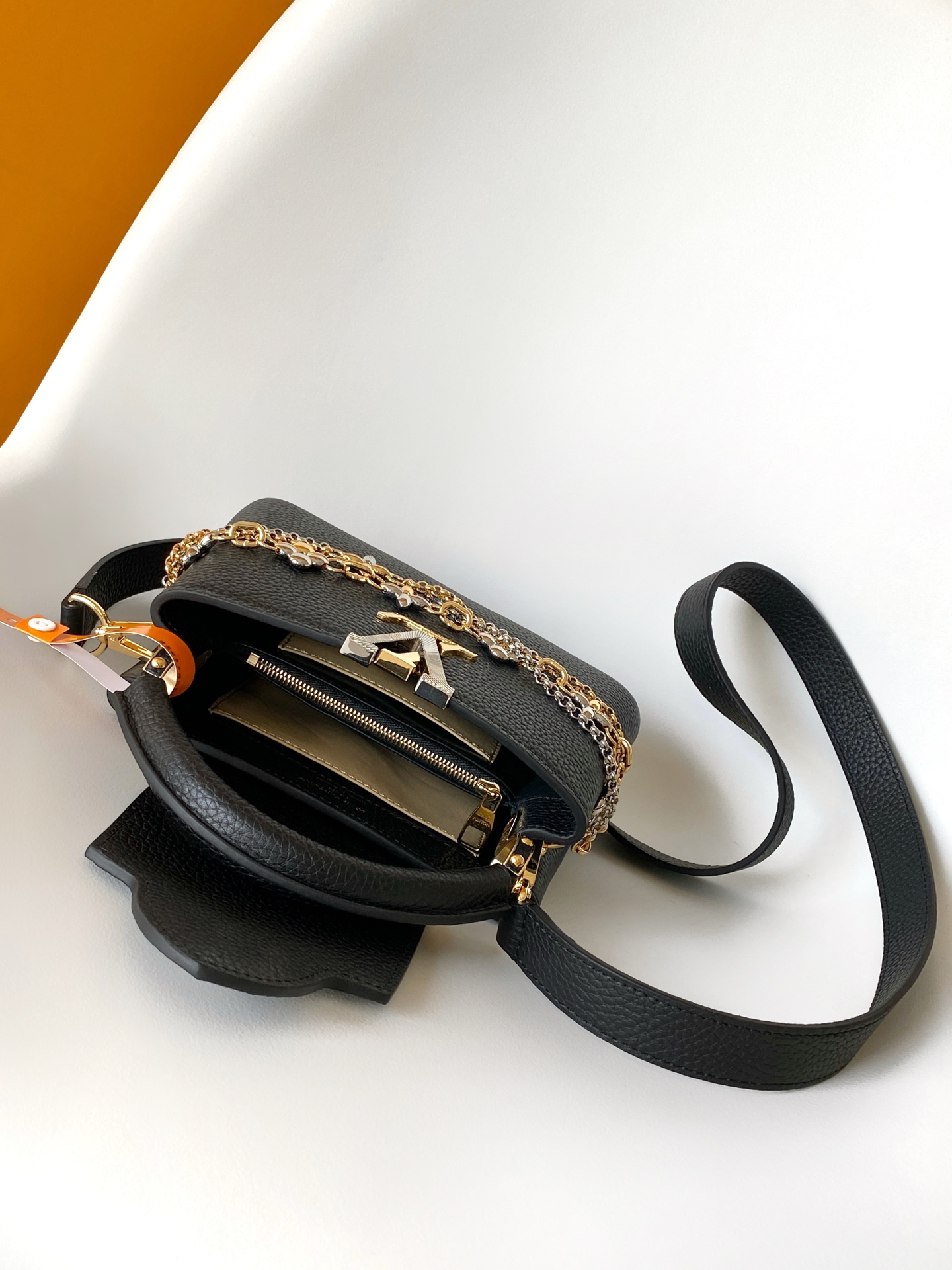 p1080💰M27035蓝色M27034紫红 M27039粉色 M26507西瓜红 M26351黑色白丽 M26814黑色 M26345米白横版Capucines Mini是一款适用于日间与夜晚场合的精致配饰。它采用由品牌珠宝启发的无限链设计，材质选用本季标志性深紫色色调的塔维尔隆皮革制成。双重镀锌五金细节，包括以放射状排列，反射光线的太阳纹工艺呈现的标志性LV首字母，增添了几分奢华感。可拆卸的肩带设计，让你既能将其作为肩包佩戴，斜挎于一侧肩头，亦可手提于顶部手柄处。
21x13.6x8厘米(长x高x宽)
27 x 17.3 x 9 (厘米) ((长 x 高 x 宽)
22 x 12 x 8 (厘米) ((长 x 高 x 宽)
横版白色
。托里昂皮革.Toryong皮革饰边。牛皮内衬
。金色与银色五金件
两种佩戴方式：可将翻盖收起或拉出。带一个平口袋的分隔内衬。底部四金属底座，用于保护
。存储：智能手机，Capucines紧凑钱包，钥匙。肩带：可拆卸，长度可调节
。肩背时最小肩带长度：46.5厘米
。肩背时最大肩带长度：54.0厘米手柄：简约