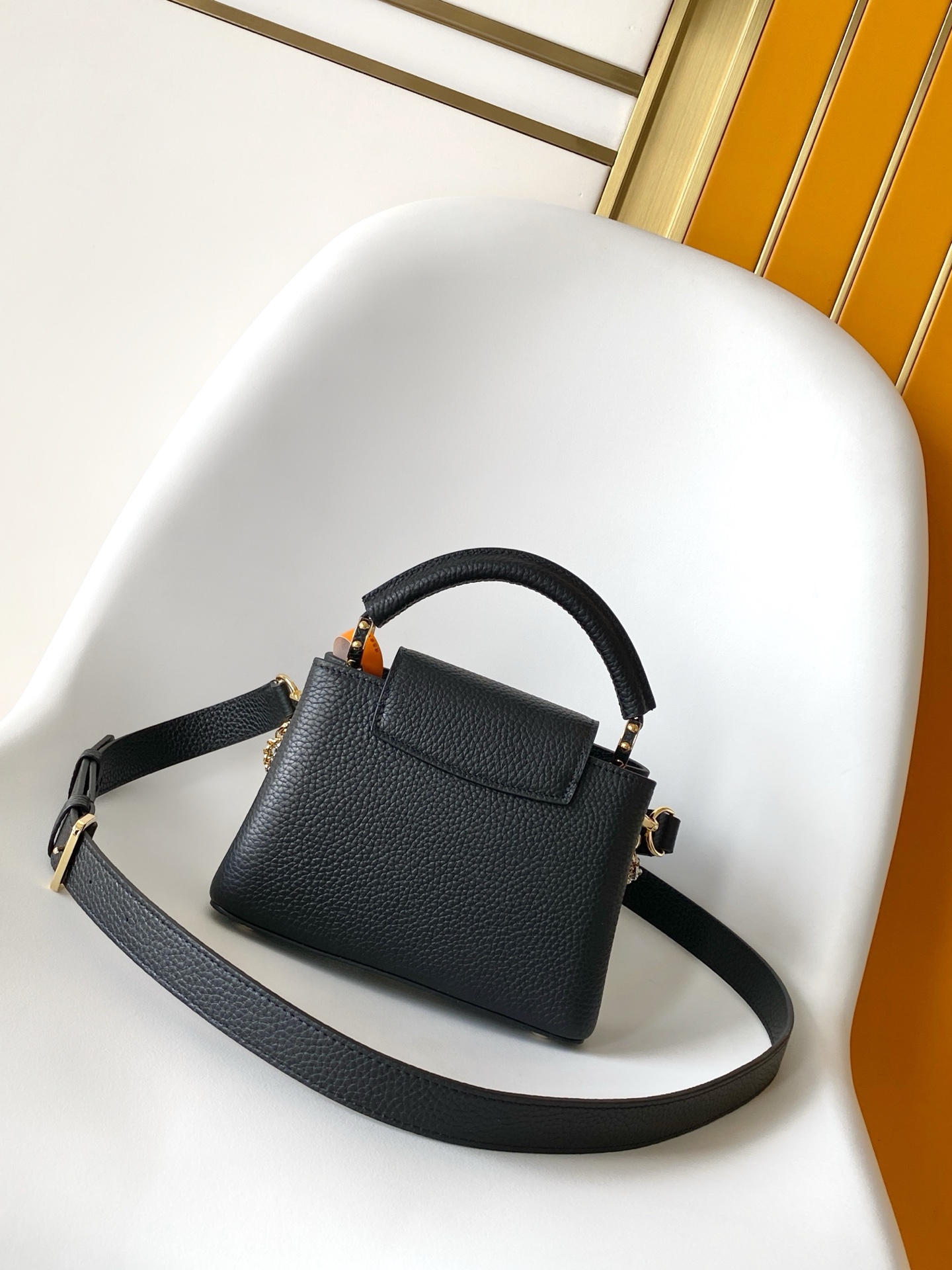 p1080💰M27035蓝色M27034紫红 M27039粉色 M26507西瓜红 M26351黑色白丽 M26814黑色 M26345米白横版Capucines Mini是一款适用于日间与夜晚场合的精致配饰。它采用由品牌珠宝启发的无限链设计，材质选用本季标志性深紫色色调的塔维尔隆皮革制成。双重镀锌五金细节，包括以放射状排列，反射光线的太阳纹工艺呈现的标志性LV首字母，增添了几分奢华感。可拆卸的肩带设计，让你既能将其作为肩包佩戴，斜挎于一侧肩头，亦可手提于顶部手柄处。
21x13.6x8厘米(长x高x宽)
27 x 17.3 x 9 (厘米) ((长 x 高 x 宽)
22 x 12 x 8 (厘米) ((长 x 高 x 宽)
横版白色
。托里昂皮革.Toryong皮革饰边。牛皮内衬
。金色与银色五金件
两种佩戴方式：可将翻盖收起或拉出。带一个平口袋的分隔内衬。底部四金属底座，用于保护
。存储：智能手机，Capucines紧凑钱包，钥匙。肩带：可拆卸，长度可调节
。肩背时最小肩带长度：46.5厘米
。肩背时最大肩带长度：54.0厘米手柄：简约