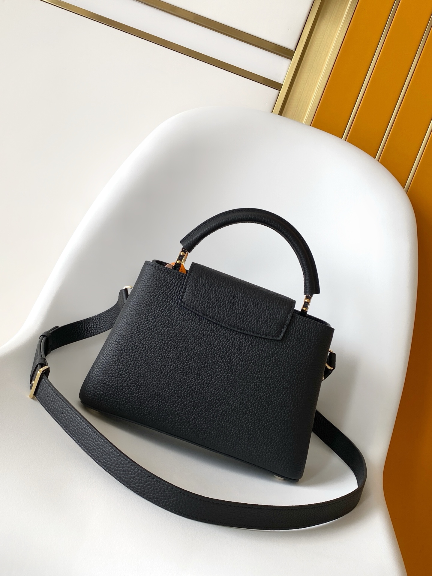 p1180💰M27035蓝色M27034紫红 M27039粉色 M26507西瓜红 M26351黑色白丽 M26814黑色 M26345米白横版Capucines Mini是一款适用于日间与夜晚场合的精致配饰。它采用由品牌珠宝启发的无限链设计，材质选用本季标志性深紫色色调的塔维尔隆皮革制成。双重镀锌五金细节，包括以放射状排列，反射光线的太阳纹工艺呈现的标志性LV首字母，增添了几分奢华感。可拆卸的肩带设计，让你既能将其作为肩包佩戴，斜挎于一侧肩头，亦可手提于顶部手柄处。
21x13.6x8厘米(长x高x宽)
27 x 17.3 x 9 (厘米) ((长 x 高 x 宽)
22 x 12 x 8 (厘米) ((长 x 高 x 宽)
横版白色
。托里昂皮革.Toryong皮革饰边。牛皮内衬
。金色与银色五金件
两种佩戴方式：可将翻盖收起或拉出。带一个平口袋的分隔内衬。底部四金属底座，用于保护
。存储：智能手机，Capucines紧凑钱包，钥匙。肩带：可拆卸，长度可调节
。肩背时最小肩带长度：46.5厘米
。肩背时最大肩带长度：54.0厘米手柄：简约