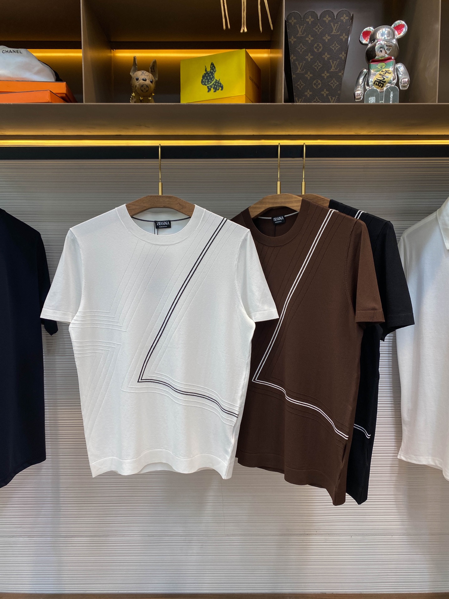 NO:143116,[-EZ25SS spring and summer new technology fiber knitted stretch round neck short Tee, men's fashionable simple lines inlay decoration casual pullover short-sleeved T-shirt knitted sweater!  Trading companies have sparse channels and are on sale on the leading official website!  Zjia’s new knitted T-shirts reveal extraordinary quality and unique fashion charm from the choice of fabric to the design!  This T-shirt uses customized technology fiber knitted fabric, which not only feels skin-friendly and comfortable, but also fits like a second layer of skin, but also has excellent elastic properties!  Whether it is daily activities or exercise, you can easily deal with it without any sense of restraint!  The design of the body of the clothes is even more ingenious, with simple but stylish contrasting lines and patterns cleverly outlined on the body of the clothes, which not only breaks the monotony of the solid-color T-shirt, but also adds a bit of fashion and vitality!  The basic round style design adds a bit of casualness and freedom to this T-shirt. It will not be too slim and restrained, nor will it lose its style!  The perfect tailoring and styling design makes this T-shirt show the best wearing effect whether worn alone or as an inner wear!  Black/white/coffee, three colors into it!  Size 48-56 Size 48-shoulder width 42cm-bust 98cm-length 64cm Size 50-shoulder width 43cm-bust 102cm-length 65cm Size 52-shoulder width 44cm-bust 106cm-length 67cm Size 54-shoulder width 45cm-bust 110cm-length 69cm Size 56-shoulder width 46cm-bust 114cm-length 71cm Size recommended (standard version) Height 174-140 catties, try on 50 sizes appropriate!  A boy can choose 48 digits within 128 catties, a 50 digit for 128-140 catties, a 52 digit for 140-153 catties, a 52 digit for 153-166 catties, a 54 digit for 166-180 catties!  ,T-shirt,tees,t-shirt,alexander wang19860909【-EZ25SS春夏新款科技纤维针织弹力圆领短Tee,男士时尚简约线条嵌花装饰休闲套头短袖T恤针织衫！贸易公司渠道稀出,领先官网发售！Z家新款针织T恤从面料的选择到设计的每一个细节,都透露着非凡的品质与独特的时尚韵味！ 这款T恤采用的客供定制科技纤维针织面料,不仅触感亲肤舒适,仿佛第二层肌肤般贴合,更拥有着出色的弹力性能！无论是日常活动还是运动时穿着,都能轻松应对,没有丝毫的束缚感！衣身上的设计更是匠心独运,简约而不失格调的对比色线条图案,巧妙地勾勒在衣身之上,既打破了纯色T恤的单调,又增添了几分时尚与活力！基础的圆版型设计,更是为这款T恤增添了几分随性与自在,它不会过于修身而显得拘谨,也不会过于宽松而失去版型！恰到好处的剪裁与版型设计,使得这款T恤无论是单穿还是作为内搭,都能展现出最佳的穿着效果！黑色/白色/咖啡,三色入！尺码48-56 48码肩宽42cm-胸围98cm-衣长64cm 50码肩宽43cm-胸围102cm-衣长65cm 52码肩宽44cm-胸围106cm-衣长67cm 54码肩宽45cm-胸围110cm-衣长69cm 56码肩宽46cm-胸围114cm-衣长71cm 尺码推荐（标准版型） 身高174-140斤,试穿50码合适！ 男生体重128斤以内选择48码,128-140斤选择50码,140-153斤选择52码,153-166斤选择54码,166-180斤选择56码！,,T-shirt,tees，t-shirt,alexander wang,Men's clothing