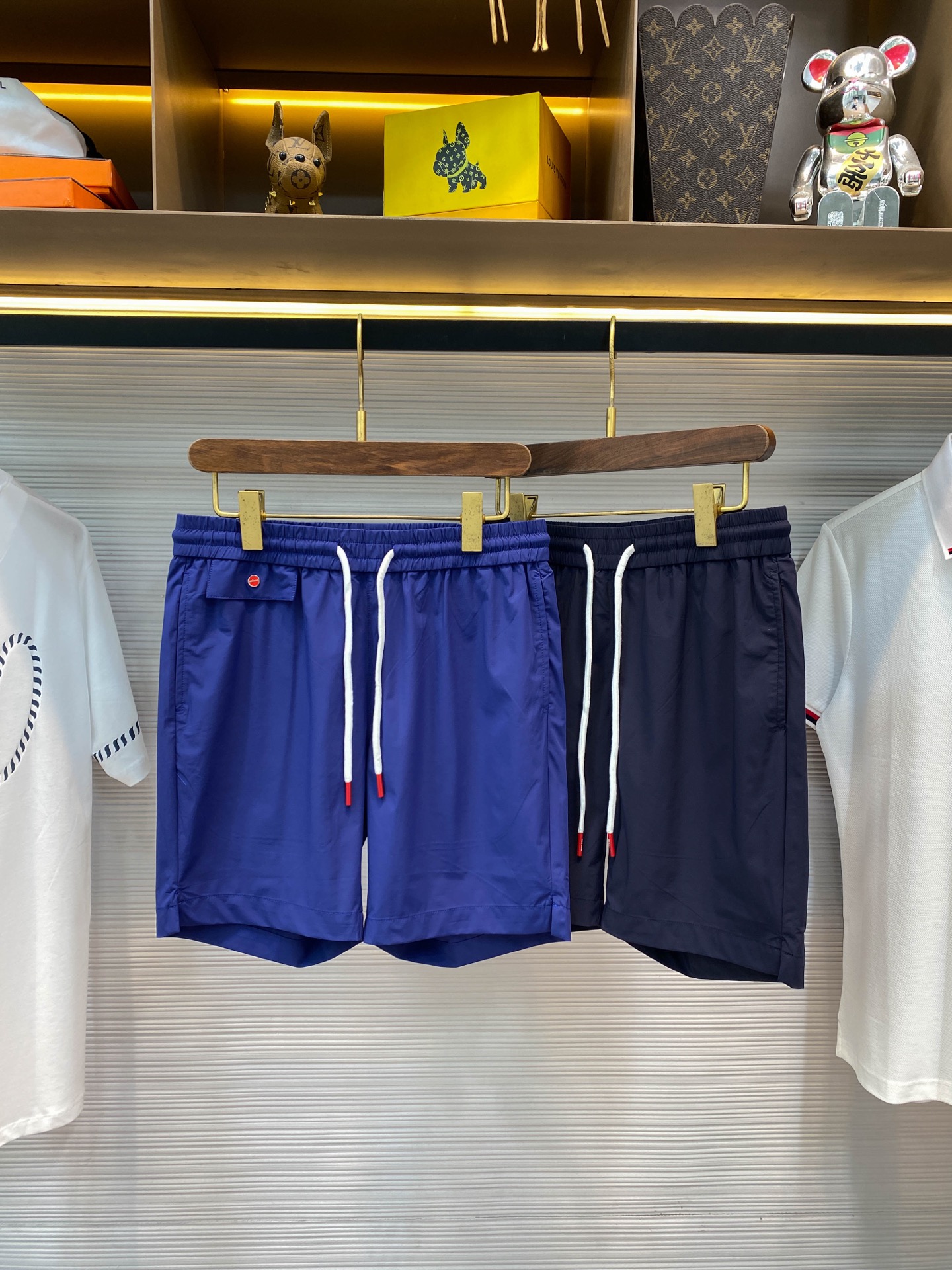 NO:446137,KITON25SS spring and summer new lightweight technology woven fabric drawstring shorts, classic red label button decorative fashionable casual shorts for men!  Trading companies have sparse channels and are on sale on the leading official website!  A exquisite item that combines fashion and comfort. Every detail reveals the brand's ultimate pursuit of quality and its keen capture of trends!  This shorts are made of customized technology woven fabrics. They are not only light and delicate in texture, but also fit like a second layer of skin, but also have excellent comfort and breathability!  Even in the hot summer, it ensures that the wearer enjoys a refreshing feeling like a breeze!  The front page with red buttons is not only bright in color, but also complements the enthusiasm of summer, and the details show the noble identity!  What is more unique is the design of the rope head hanging bell. It cleverly incorporates brand elements, which is small and exquisite, swaying gently with the pace, as if whispering the brand story, which is both fashionable and eye-catching!  It forms a perfect echo with the embroidered letter logo on the back pocket. The embroidery craftsmanship and the smooth lines of the letters not only add to the artistic sense of the shorts, but also deeply demonstrates KITON's brand tone and cultural heritage!  The drawstring elastic waist design is adopted in the style. This design not only gives the wearer greater freedom, but can easily adjust the most comfortable tightness in daily leisure or outdoor activities, but also adds a bit of casualness and unruly to the overall shape!  The straight-tube style design cleverly embodies the leg lines, which can be easily controlled whether it is tall or medium-sized, showing a simple but stylish attitude!  Royal blue/dark blue, two colors into it!  Size M-3XL M size waist 76/82cm-Hip circumference 98cm-front 27cm-thigh circumference 60cm-trouser length 43cm L size waist 79/85cm-hip circumference 102cm-front 28cm-thigh circumference 61cm-trouser length 44cm XL size waist 82/88cm-hip circumference 106cm-front 28cm-thigh circumference 62cm-trouser length 45cm XXL size waist 85/91cm-thigh circumference 110cm-front 29cm-thigh circumference 64cm-trouser length 46cm 3XL size waist 88/94cm-thigh circumference 114cm-front 29cm-thigh circumference 66cm-trouser length 47cm Size recommendation (standard version)  Height is 174-catties, it is suitable to try on the L size!  A boy can choose M code within 130 catties, a L code for 130-143 catties, a XL code for 143-156 catties, a XXL code for 156-170 catties, and a 3XL code for 170-185 catties!  ,,shorts,alexander wang19860909KITON25SS春夏新款轻薄科技梭织面料抽绳短裤,男士经典红标纽扣装饰时尚休闲短裤五分裤！贸易公司渠道稀出,领先官网发售！一款集时尚与舒适于一身的精致单品,其每一处细节都透露着品牌对品质的极致追求与对潮流的敏锐捕捉！ 这款短裤采用的是客供定制的科技梭织面料,不仅质地轻薄细腻,如同第二层肌肤般贴合,还拥有着卓越的舒爽透气性！即便是炎炎夏日,也能确保穿着者享受如微风拂面般的清爽感受！红色纽扣点缀前幅,不仅色彩鲜明,与夏日的热情相得益彰,细节之处彰显尊贵身份！更为独特的是绳头吊钟的设计,它巧妙地融入了品牌元素,小巧而精致,随着步伐轻轻摇曳,仿佛在低语品牌的故事,既时髦又抢眼！与后兜上的刺绣字母标识形成了完美的呼应,刺绣工艺精湛,字母线条流畅,不仅增添了短裤的艺术感,更深刻地展现了KITON的品牌调性与文化底蕴！ 在版型上采用了抽绳松紧裤腰设计,这一设计不仅赋予了穿着者更大的自由度,无论是日常休闲还是户外活动,都能轻松调节至最舒适的松紧度,同时也为整体造型增添了几分随性与不羁！直筒的版型设计,则巧妙地修饰了腿部线条,无论是高挑身材还是中等体型,都能轻松驾驭,展现出简约而不失格调的时尚态度！宝蓝色/深蓝色,两色入！尺码M-3XL M码腰围76/82cm-臀围98cm-前档27cm-大腿围60cm-裤长43cm  L码腰围79/85cm-臀围102cm-前档28cm-大腿围61cm-裤长44cm  XL码腰围82/88cm-臀围106cm-前档28cm-大腿围62cm-裤长45cm  XXL码腰围85/91cm-臀围110cm-前档29cm-大腿围64cm-裤长46cm  3XL码腰围88/94cm-臀围114cm-前档29cm-大腿围66cm-裤长47cm 尺码推荐（标准版型） 身高174-斤,试穿L码合适！ 男生体重130斤以内选择M码,130-143斤选择L码,143-156斤选择XL码,156-170斤选择XXL码,170-185斤选择3XL码！,,shorts,alexander wang,Men's clothing