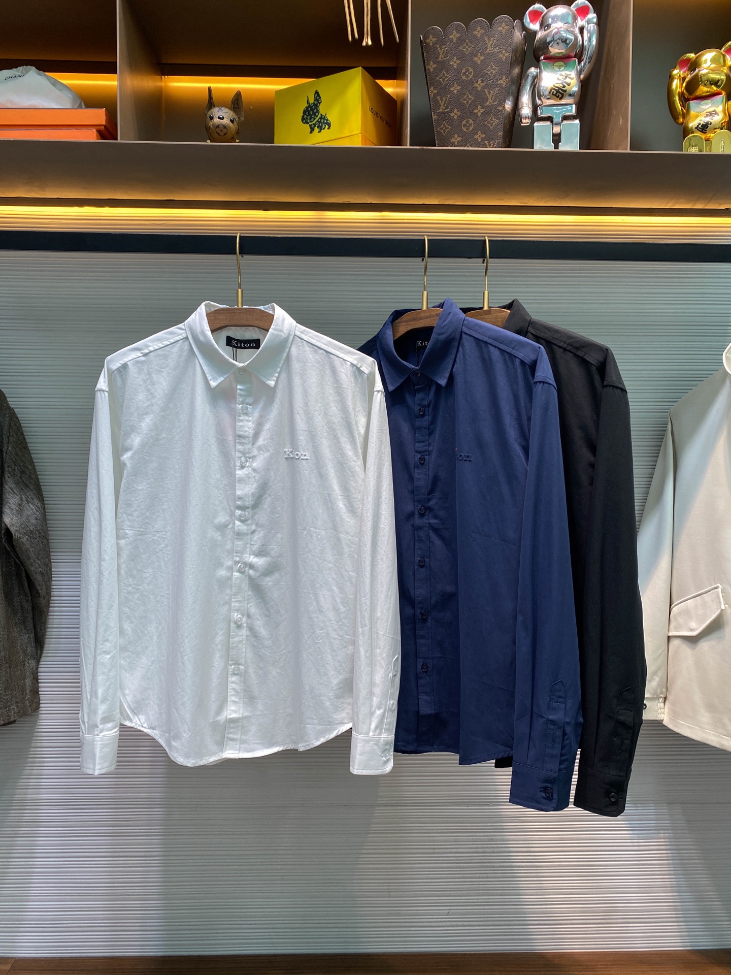 NO:568231,KITON25FW new autumn and winter high-density twill cotton lapel shirt, men's three-dimensional rubber logo loose casual long-sleeved shirt!  Trading company channels are rare and available on the official website simultaneously!  In the vast world of fashion, there are always some items that are like bright stars, attracting everyone's attention with their unique charm!  And this shirt is such an eye-catching existence. From the fabric to the details, every aspect of it shows unparalleled sophistication and luxury!  This shirt is made of imported high-density twill cotton. The high-density weaving process gives it a thick and crisp character. The whole shirt can perfectly fit the curves of the body when worn behind the back without appearing tight. It always maintains an elegant and crisp posture!  The unique three-dimensional rubber letter logo on the chest instantly attracted everyone's attention. The surface of the letters has unique textures. These textures are like traces of careful carving by artists, adding a high-level sense of detail to the entire logo!  Customized brand-engraved mother-of-pearl buttons, each button is like a treasure picked from the deep sea. The mother-of-pearl material gives the buttons a warm luster, and when illuminated by light, they will emit a soft and charming light!  Loose-cut tailoring is undoubtedly a fashion trend. It breaks the constraints of traditional shirts and gives the body enough free space!  Black/white/sapphire blue, three colors included!  Sizes S-XL S size shoulder width 55cm-bust 116cm-shirt length 74cm-sleeve length 62cm M size shoulder width 56cm-chest 120cm-shirt length 76cm-sleeve length 63cm L size shoulder width 57cm-bust 124cm-shirt length 78cm-sleeve length 64cm XL size shoulder width 58cm-chest 128cm-shirt length 80cm-sleeve length 65cm  Recommended size (loose fit) If you are 174-140 pounds tall, try on size S which is suitable!  Boys weighing less than 145 kilograms should choose S size, 145-160 kilograms should choose M size, 160-175 kilograms should choose L size, and 175-190 kilograms should choose XL size!  ,,shirts,alexander wang19860909KITON25FW秋冬新款高密度斜纹棉质翻领衬衣,男士立体橡胶标识宽松休闲长袖衬衫！贸易公司渠道稀出,同步官网发售！在时尚的广袤天地中,总有一些单品宛如璀璨星辰,以独特的魅力吸引着众人的目光！而这款衬衫便是这样一件令人瞩目的存在,它从面料到细节,每一处都彰显着无与伦比的精致与奢华！ 这款衬衫采用客供进口高密度斜纹棉布,高密度的编织工艺赋予了它厚实挺括的特质,使得整件衬衫穿上身后,能够完美地贴合身体曲线,却又不会显得紧绷,始终保持着一种优雅的挺括姿态！胸前独特的立体橡胶字母标识,瞬间吸引了所有人的注意,字母表面有着独特的纹理,这些纹理如同艺术家精心雕琢的痕迹,为整个标识增添了一份高级的细节感！客供定制的品牌刻印母贝扣,每一颗扣子都像是从深海中采撷而来的珍宝,母贝的材质赋予了扣子温润的光泽,在光线的照耀下,会散发出柔和而迷人的光芒！宽松版型裁剪无疑是一种时尚的潮流.它打破了传统衬衫的束缚感,给予身体足够的自由空间！黑色/白色/宝蓝,三色入！尺码S-XL S码肩宽55cm-胸围116cm-衣长74cm-袖长62cm  M码肩宽56cm-胸围120cm-衣长76cm-袖长63cm  L码肩宽57cm-胸围124cm-衣长78cm-袖长64cm  XL码肩宽58cm-胸围128cm-衣长80cm-袖长65cm  尺码推荐（宽松版型） 身高174-140斤,试穿S码合适！ 男生体重145斤以内选择S码,145-160斤选择M码,160-175斤选择L码,175-190斤选择XL码！,,shirts,alexander wang,Men's clothing