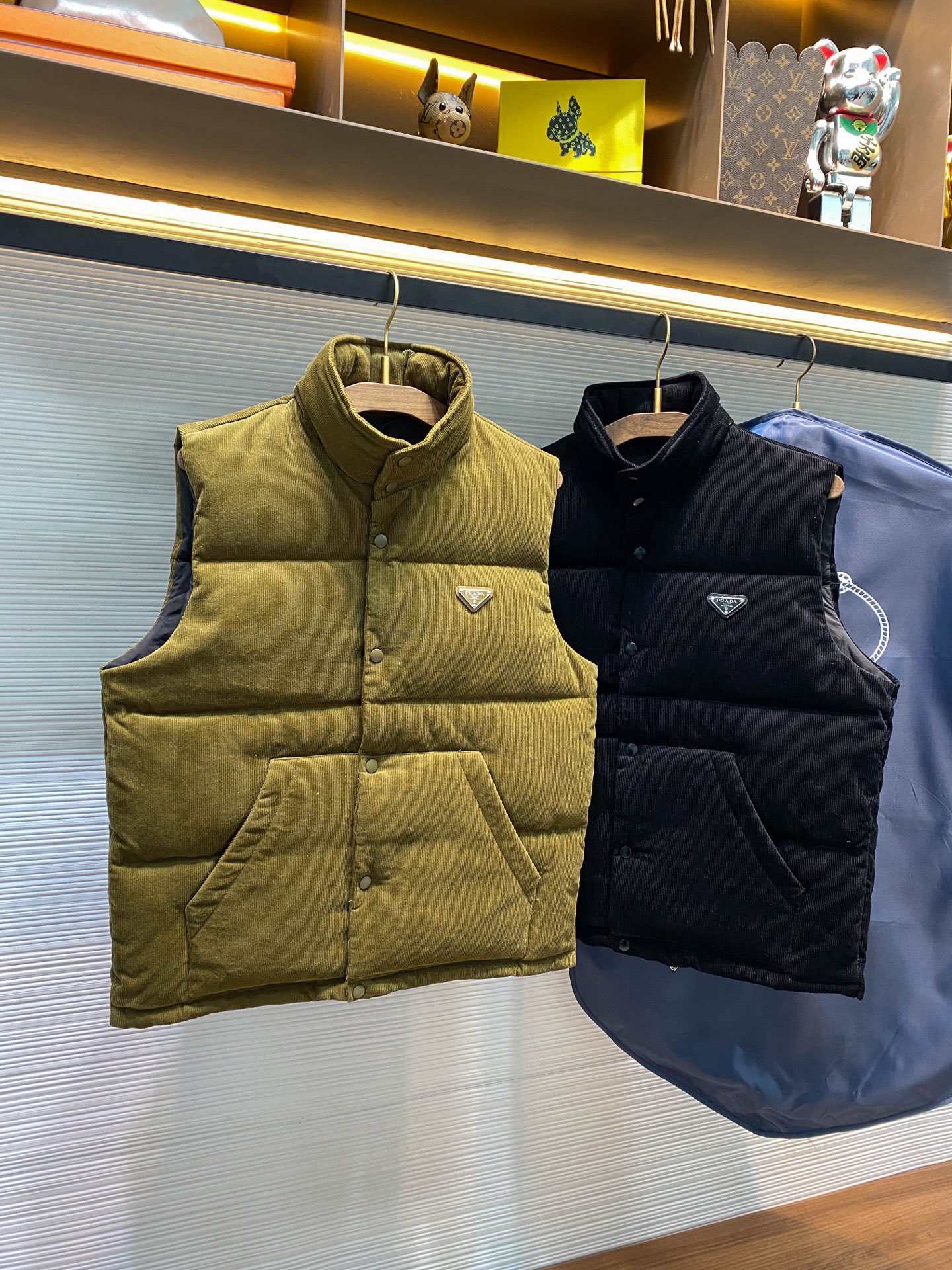 PRA25FW秋冬新款灯芯绒全棉拉链羽绒马甲，男女同款金属三角标徽章可收纳式连帽立领羽绒服马甲外套！贸易