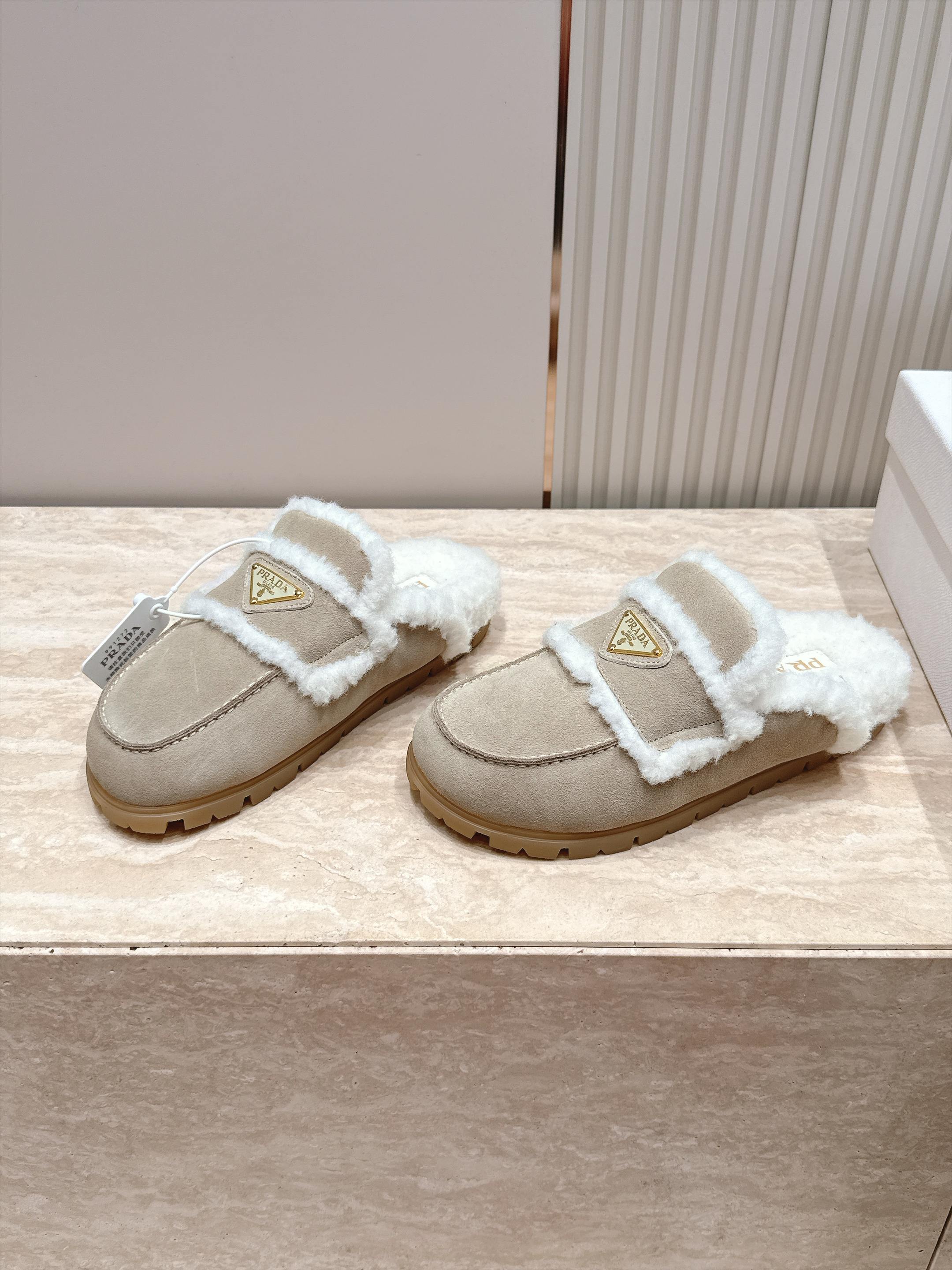 Prada 普拉达 26 秋冬三角扣复古包头半拖毛拖 这双毛拖无疑是先锋美学与慵懒格调的惊艳融合。标志性的三角扣以利落线