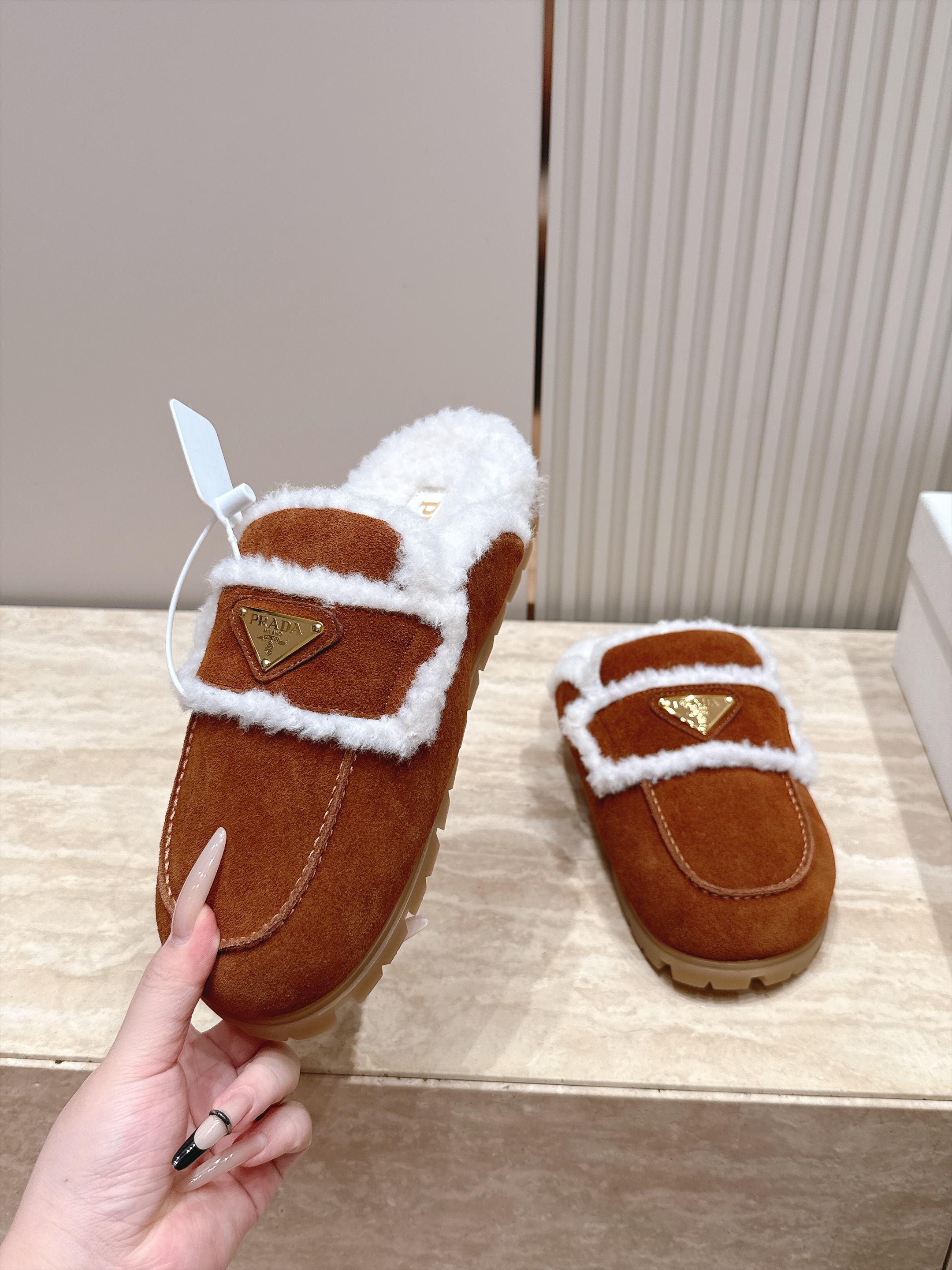 Prada 普拉达 26 秋冬三角扣复古包头半拖毛拖 这双毛拖无疑是先锋美学与慵懒格调的惊艳融合。标志性的三角扣以利落线 Prada 普拉达 26 秋冬三角扣复古包头半拖毛拖 这双毛拖无疑是先锋美学与慵懒格调的惊艳融合。标志性的三角扣以利落线