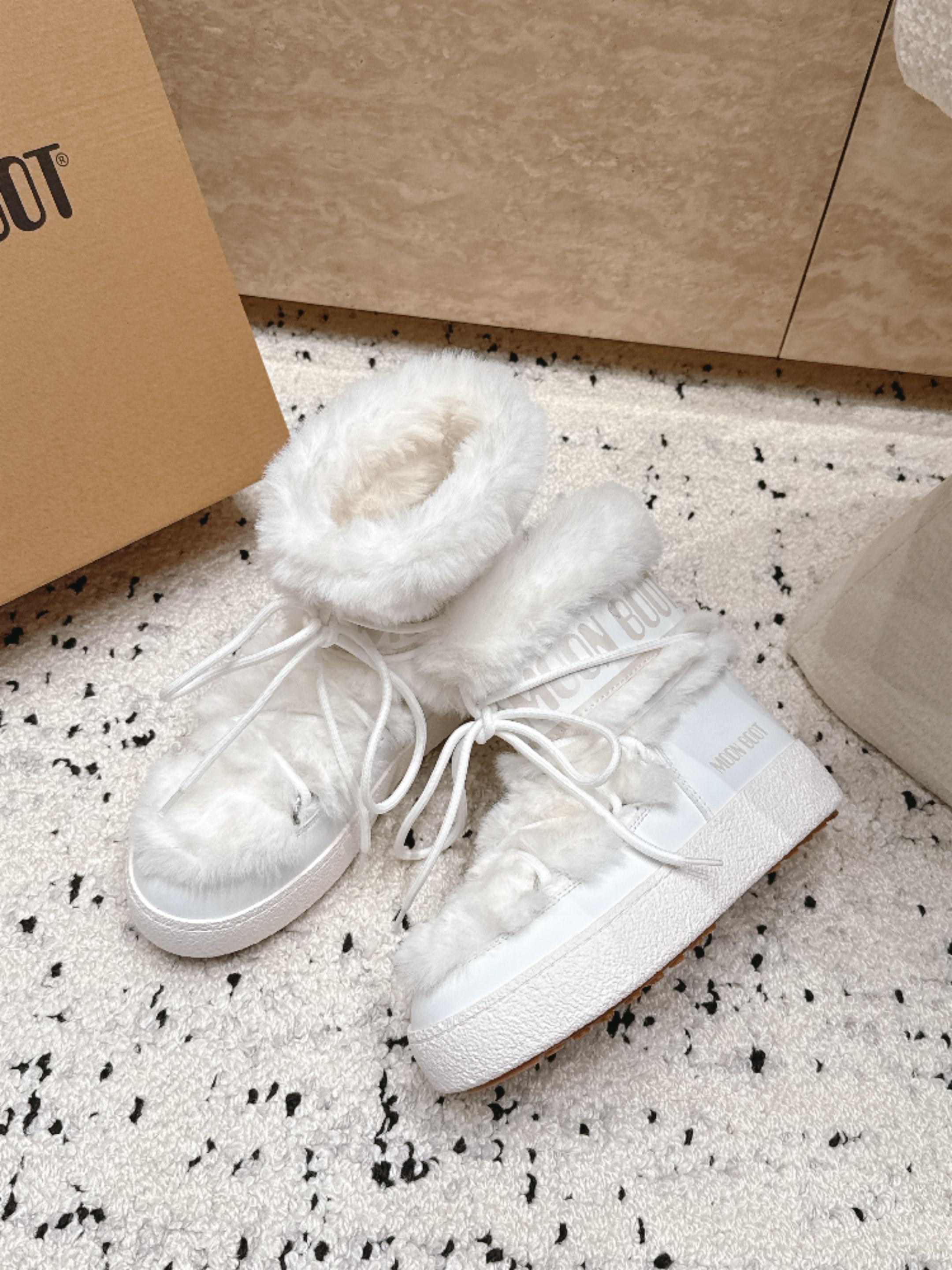 Moon Boot毛绒绑带雪地靴｜冬日甜酷保暖单品 Moon Boot这款毛绒雪地靴，妥妥是冬日氛围感担当，黑色和奶白双