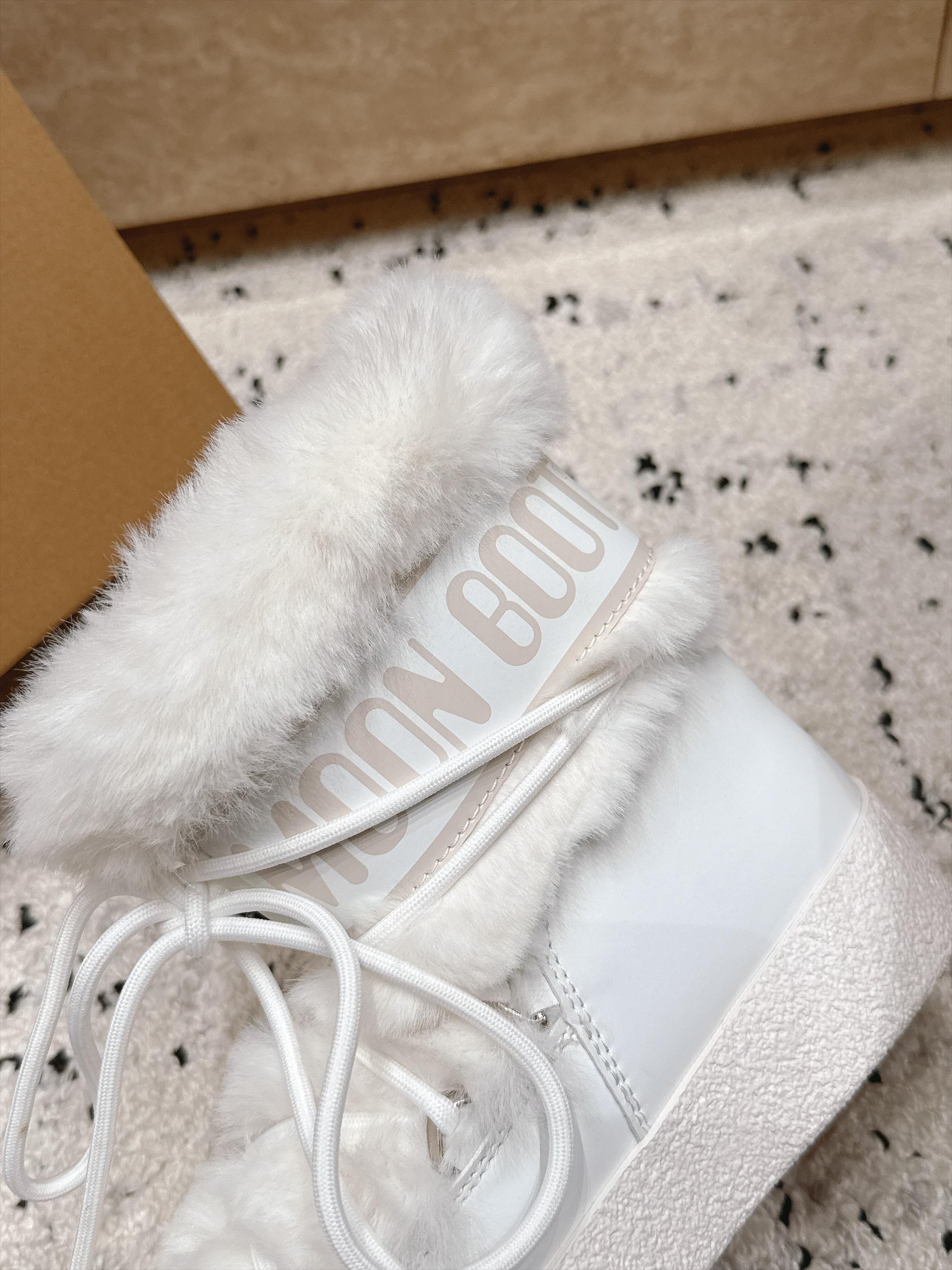 Moon Boot毛绒绑带雪地靴｜冬日甜酷保暖单品 Moon Boot这款毛绒雪地靴，妥妥是冬日氛围感担当，黑色和奶白双